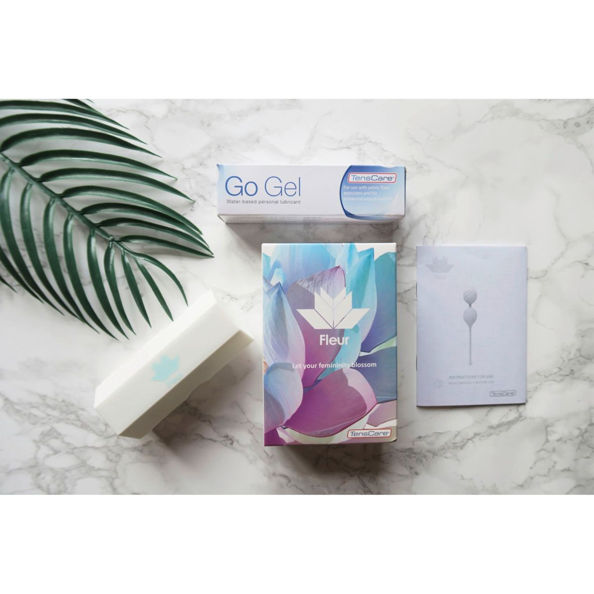 Verschiedene feminine Hygieneprodukte auf Marmor, einschließlich Gleitmittel und Tücher.