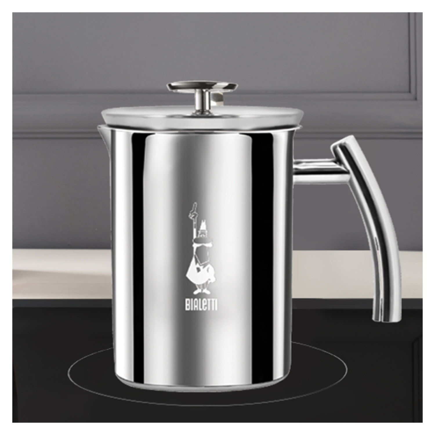 Srebrny zaparzacz do kawy Bialetti na blacie. Tło jest szare.
