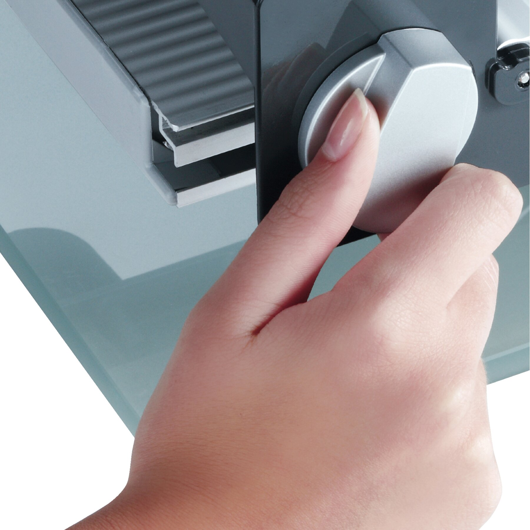 Ręka obracająca szare pokrętło na jasnoszarej maszynie.