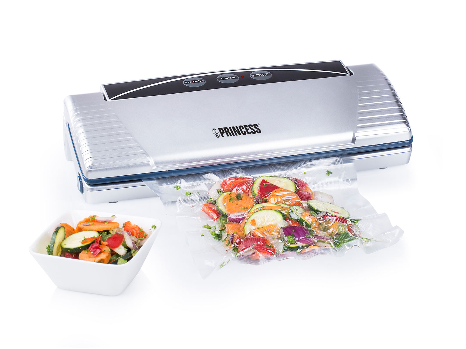 Srebrna zgrzewarka próżniowa z warzywami w worku. Biała miska sałatki obok.