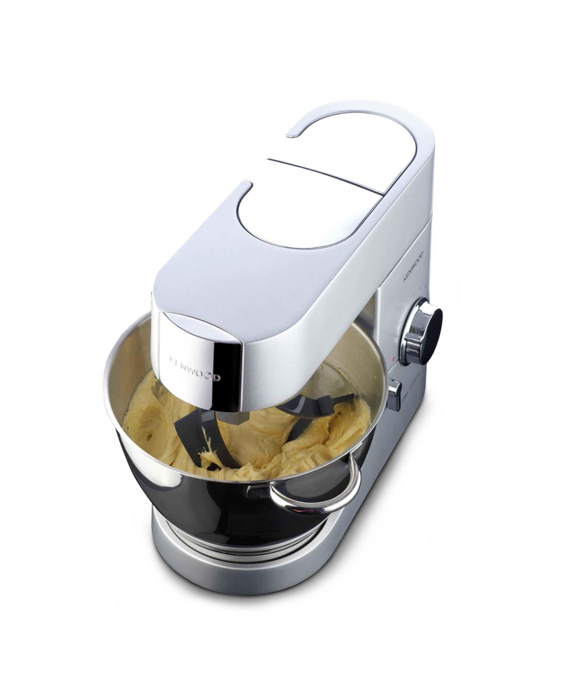 Ein silberner Küchenmixer mit einer Schüssel mit gelbem Teig, auf weißem Hintergrund.