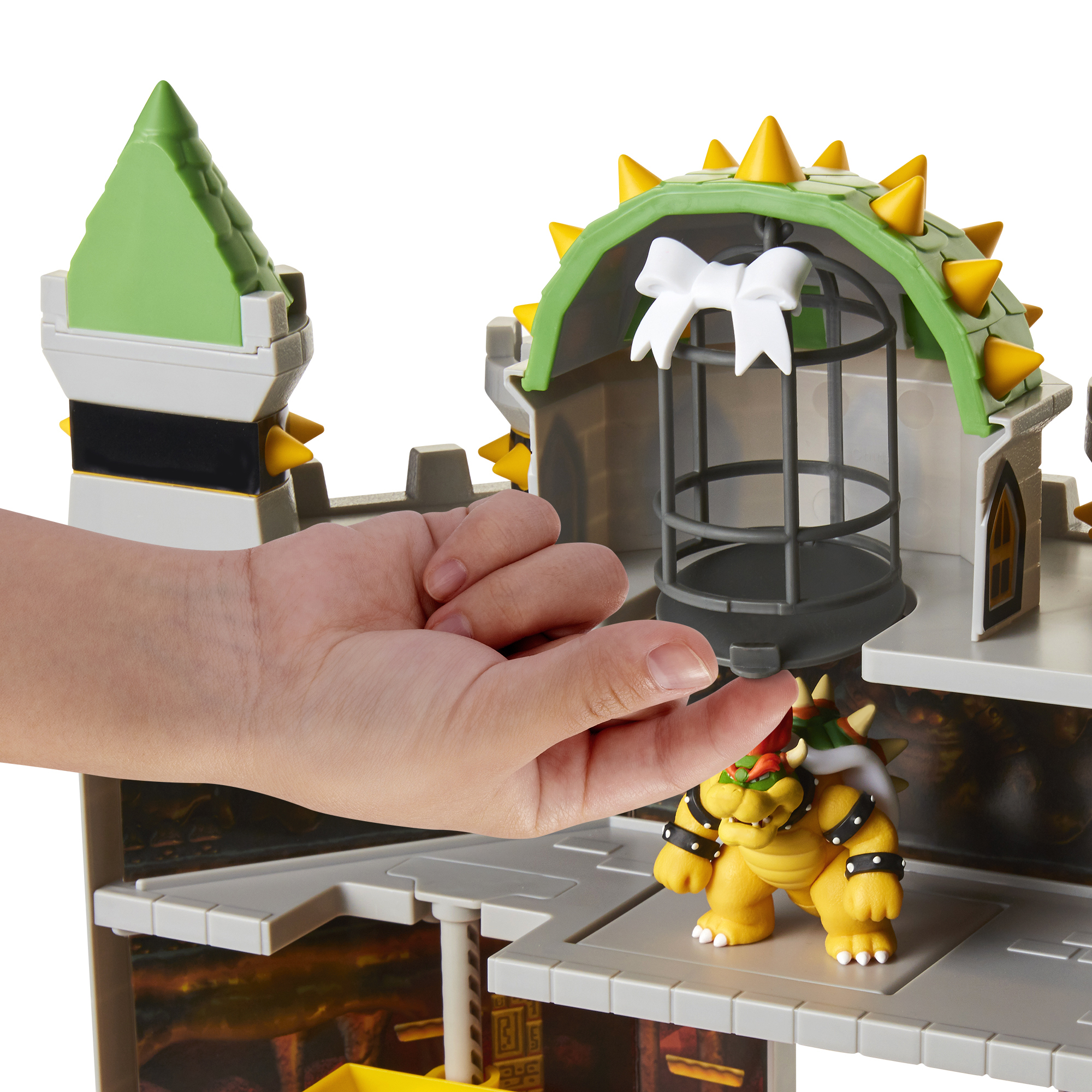 Hand in der Nähe eines Bowser-Spielzeugs, Teil eines bunten Burg-Spielsets.