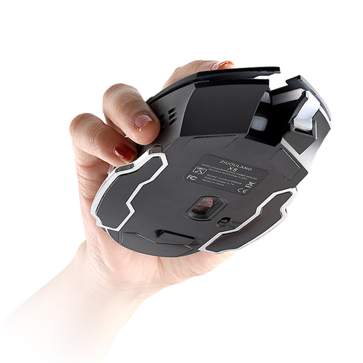 Eine Hand, die eine schwarz-graue Gaming-Maus hält, Unteransicht. Weißer Hintergrund.