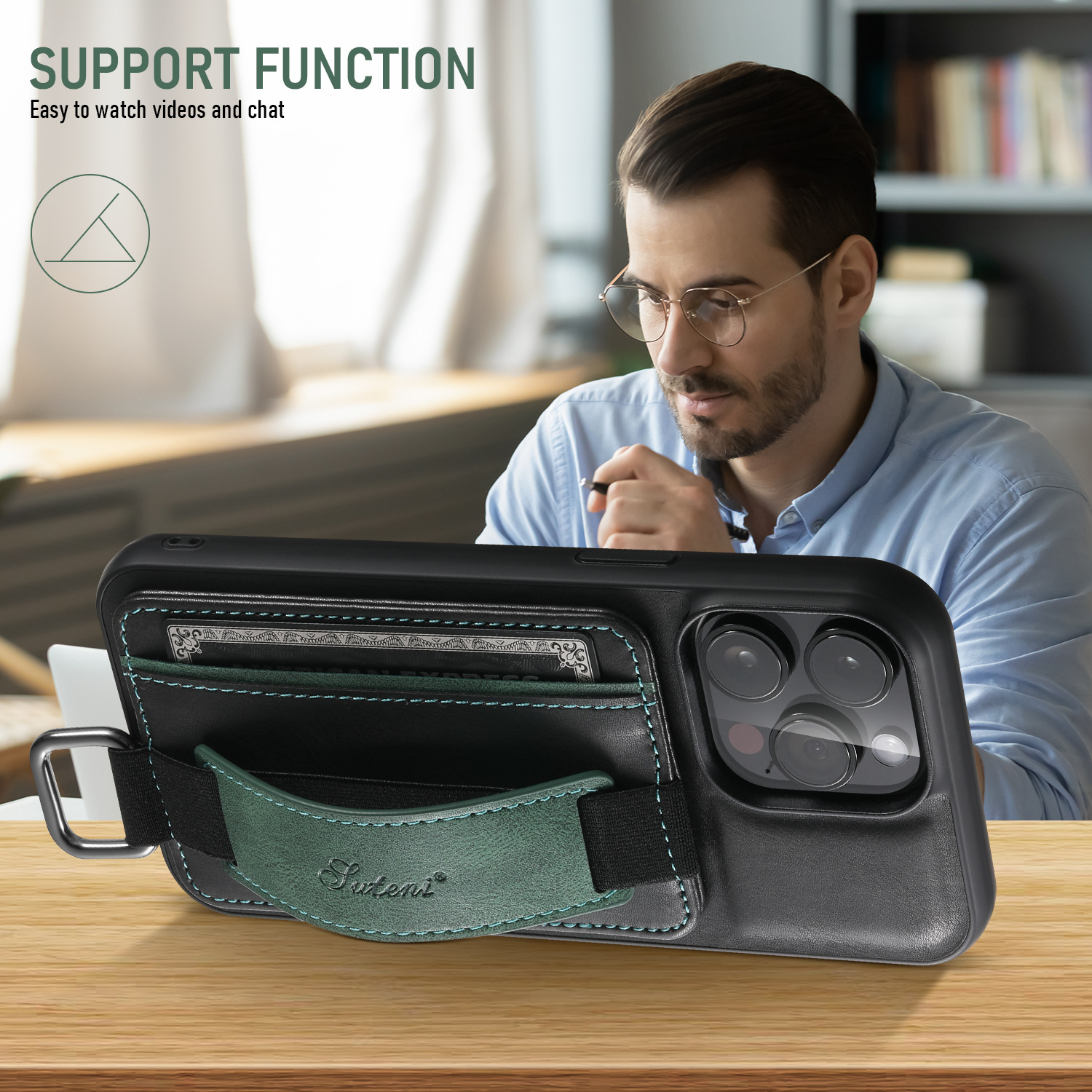 Un hombre usando una funda negra de teléfono con una correa verde y una cartera sobre una mesa de madera.