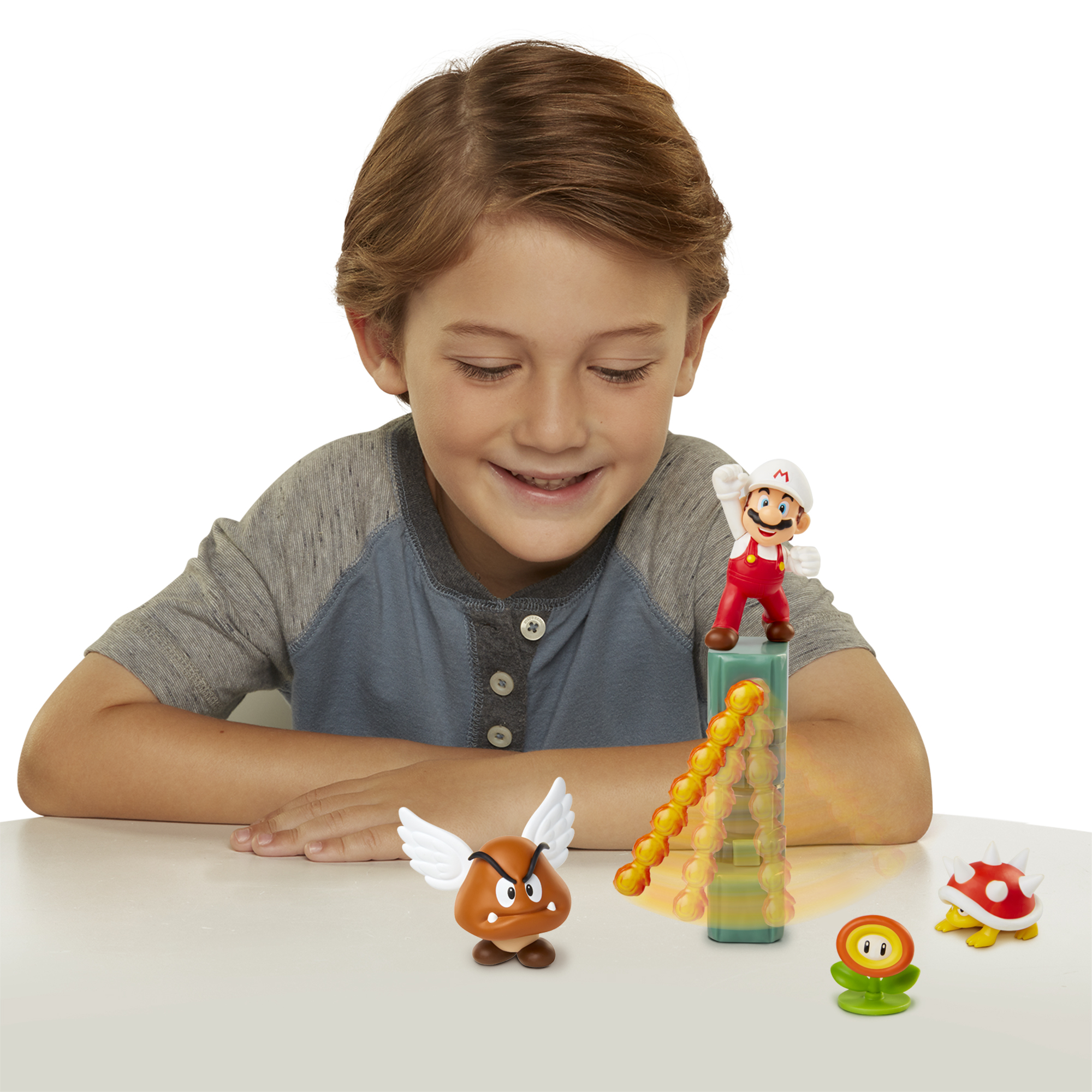 Junge spielt mit Mario-Spielzeug. Goomba, Feuer-Mario und Blume.