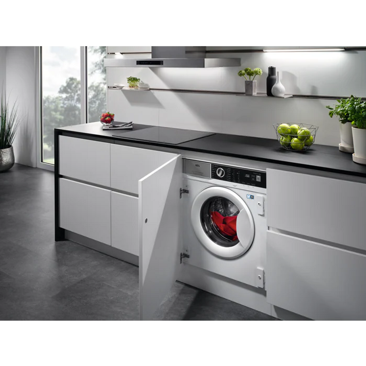 Nowoczesna kuchnia z białymi szafkami, pralką i czarnym blatem.