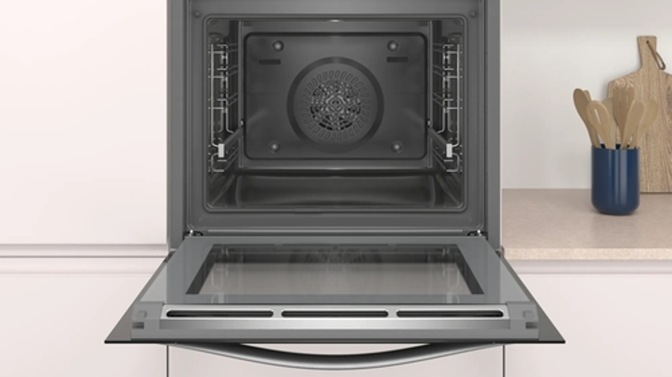 Horno abierto con puerta de cristal, interior visible, contra pared blanca.