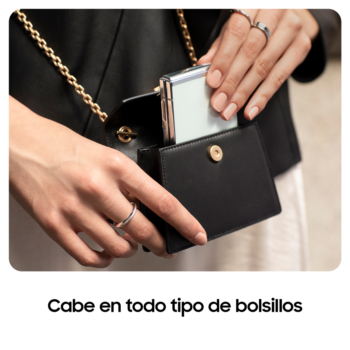Ręce trzymają małą czarną torebkę z telefonem w środku. Tekst "Mieści się we wszystkich kieszeniach" poniżej.