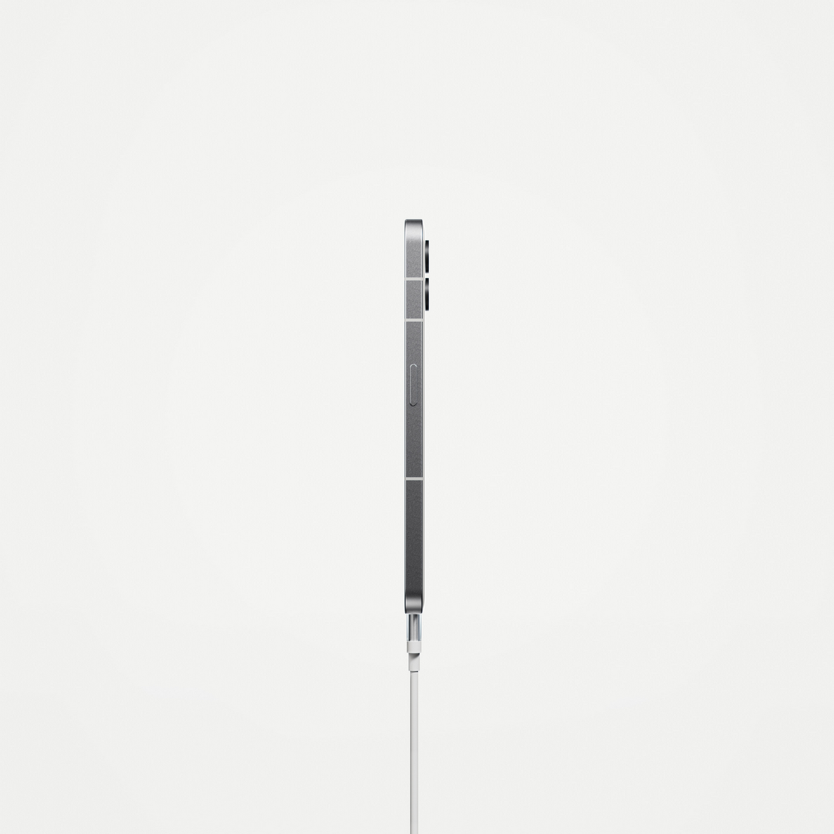 Ein silbernes Smartphone im Profil mit angeschlossenem Ladekabel. Der Hintergrund ist weiß.
