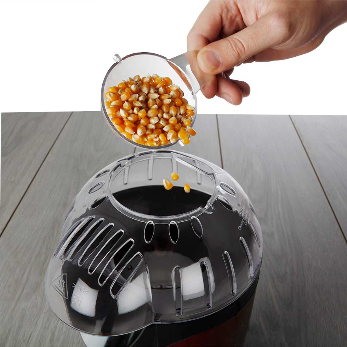 Máquina de palomitas con granos vertiéndose en ella.