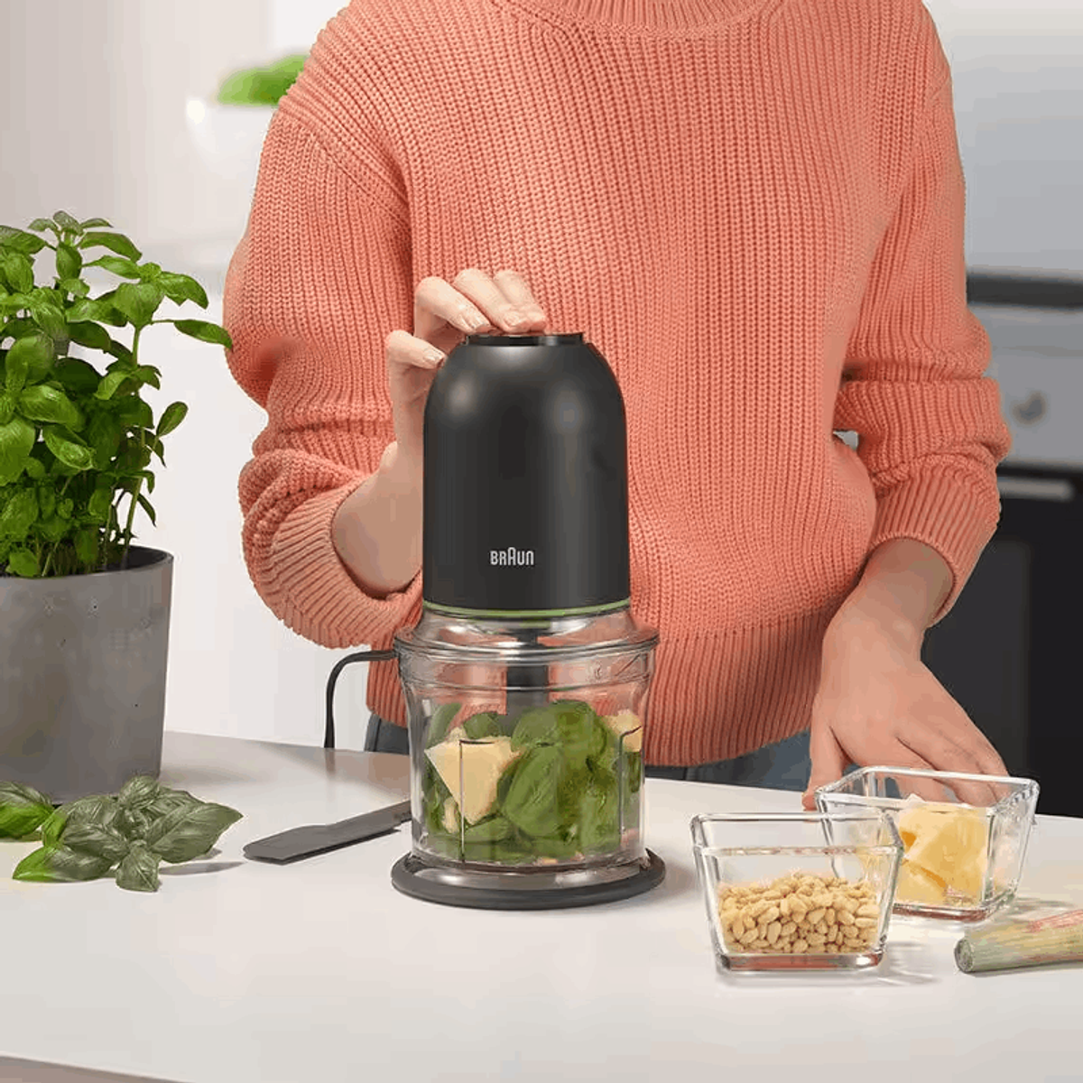Persona che utilizza un robot da cucina con ingredienti all'interno.