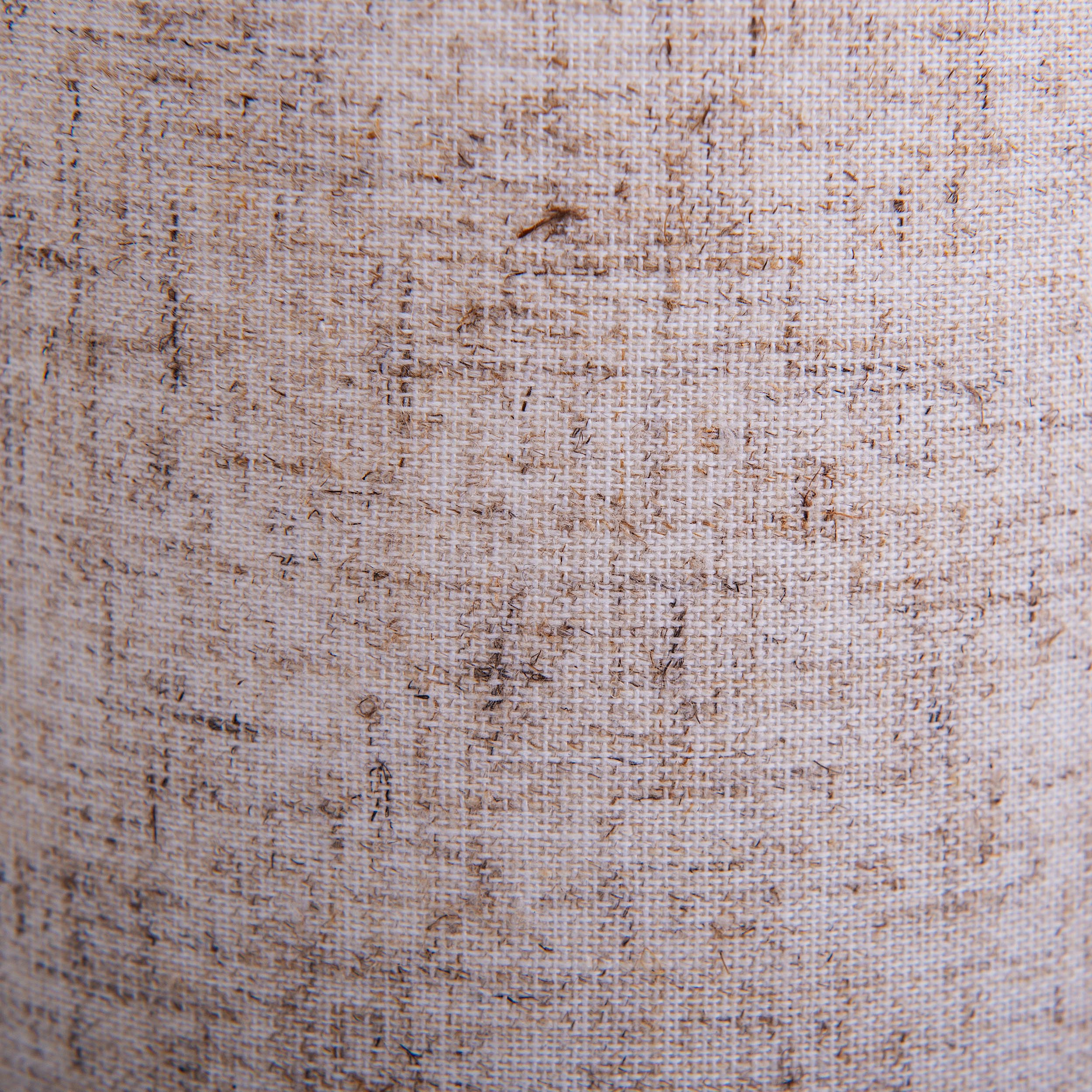 Nahaufnahme eines beigen Stoffes mit rauer, gewebter Textur, die Oberfläche des Materials zeigend.