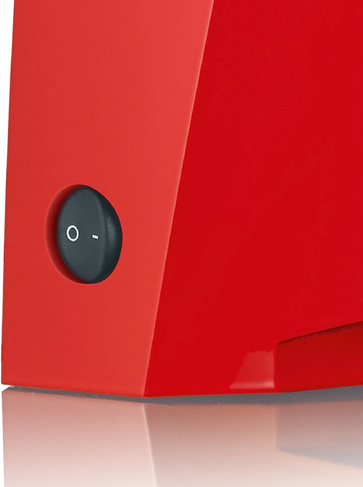Zbliżenie czerwonego urządzenia z czarnym przyciskiem zasilania, na białym tle.
