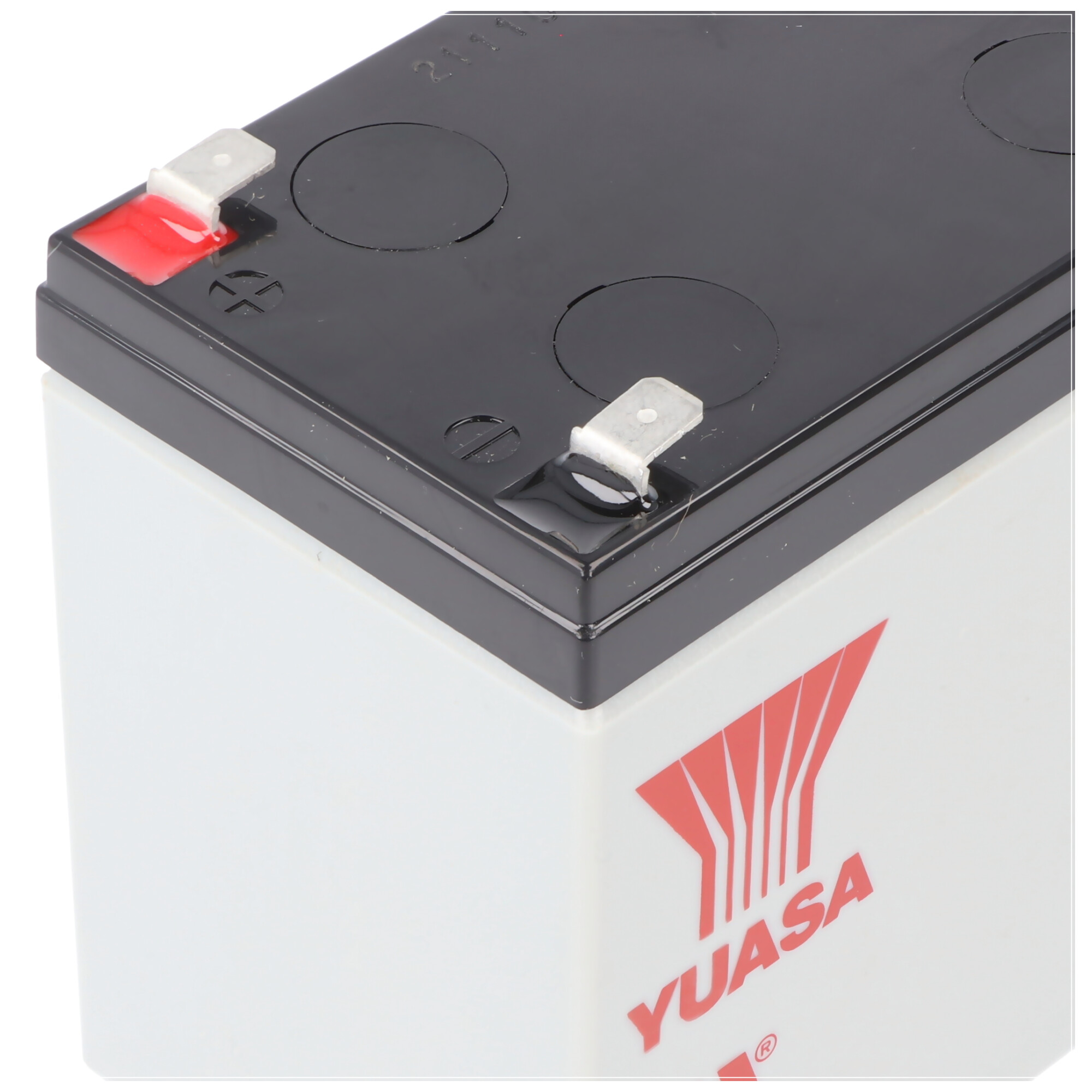 Weiße Batterie mit roten und schwarzen Anschlüssen und dem Wort 'YUASA' in Rot auf der Vorderseite.