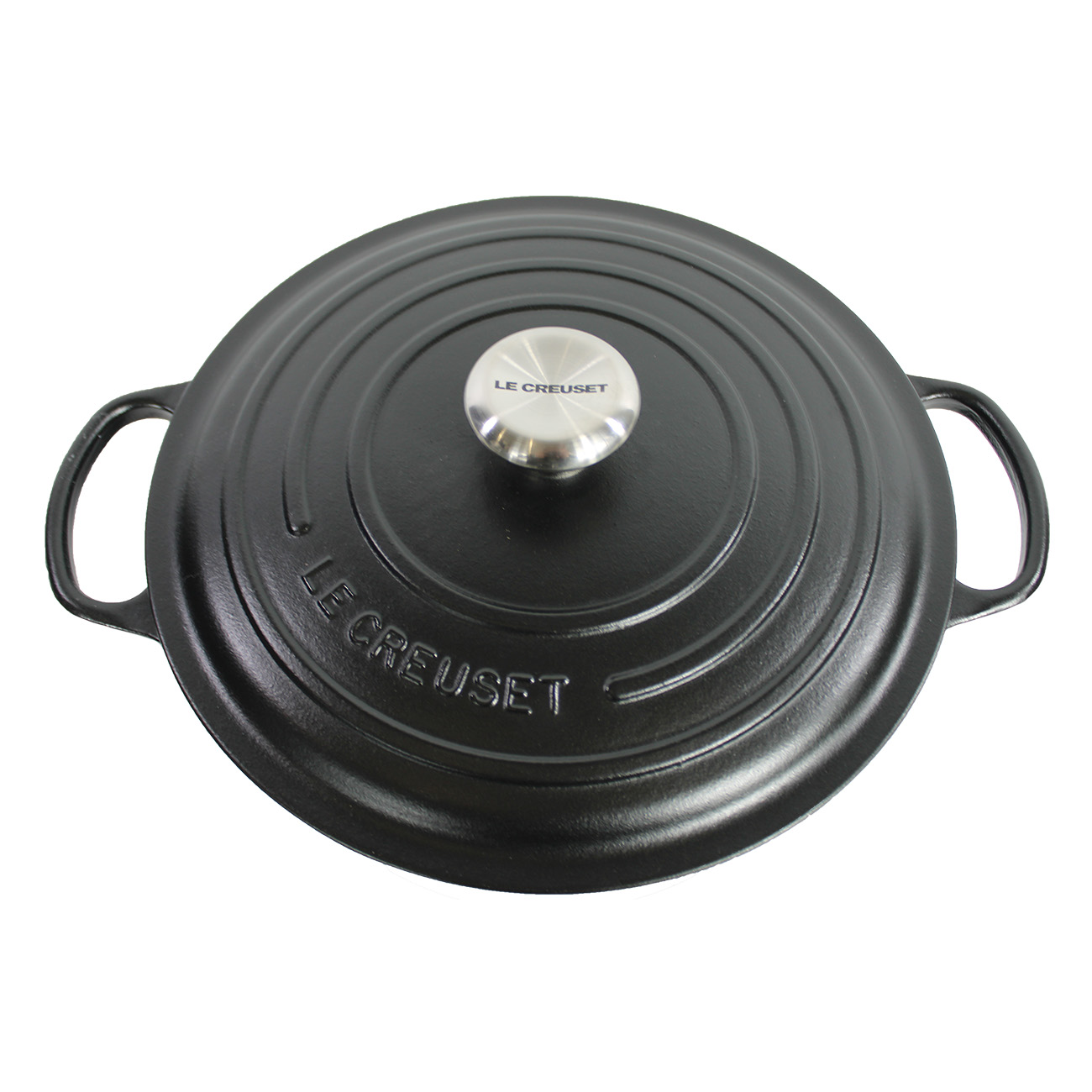Une casserole Le Creuset noire avec couvercle. La casserole a une forme ronde avec poignées.
