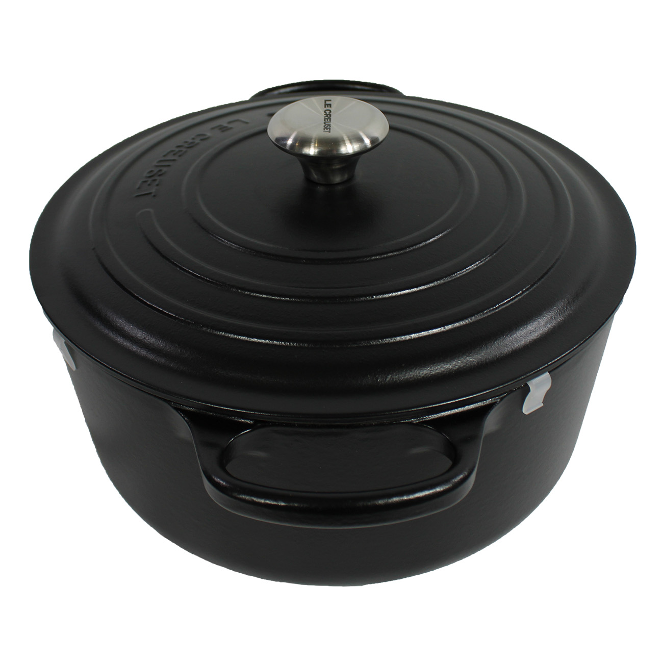 Casserole noire Le Creuset avec couvercle et anses, sur fond blanc. Le couvercle a un bouton argenté.