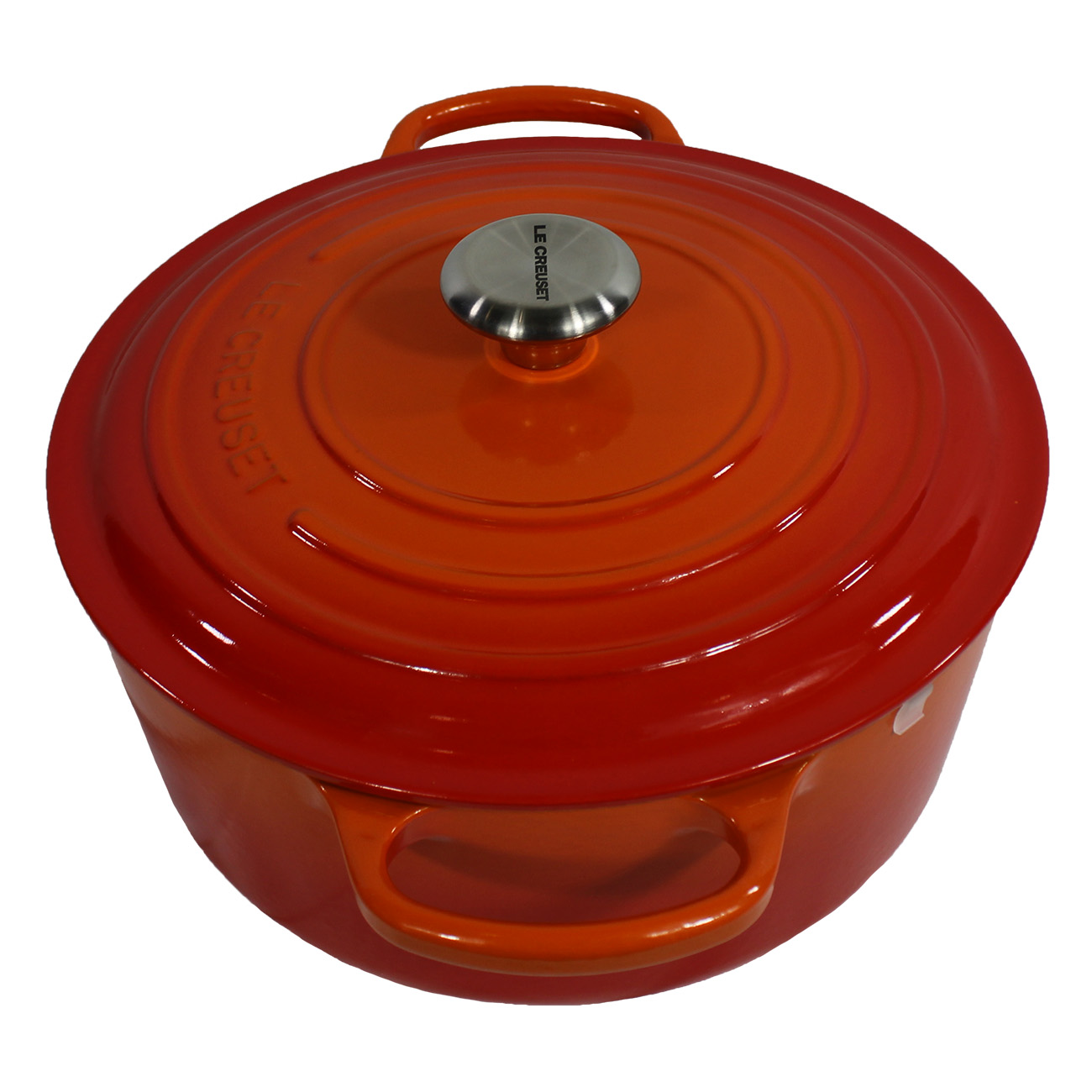 Orangener Le Creuset Topf mit silbernem Griff auf weißem Hintergrund. Es hat einen Deckel.