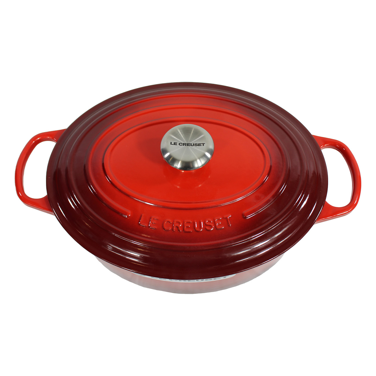 Roter ovaler Le Creuset Topf mit silbernem Deckel. Der Topf steht auf weißem Hintergrund.