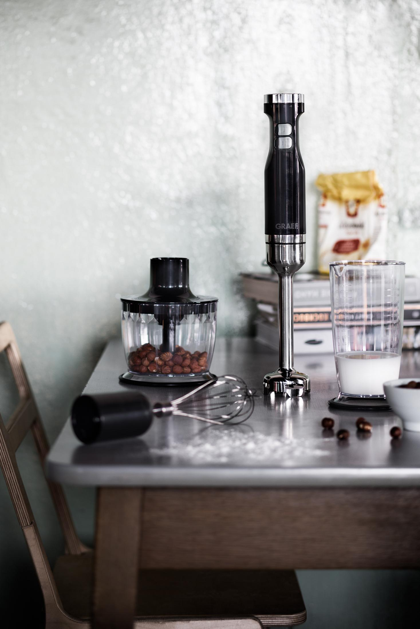 Blender na stole ze składnikami. Przezroczysty szklanka z mlekiem. Drewniany stół.