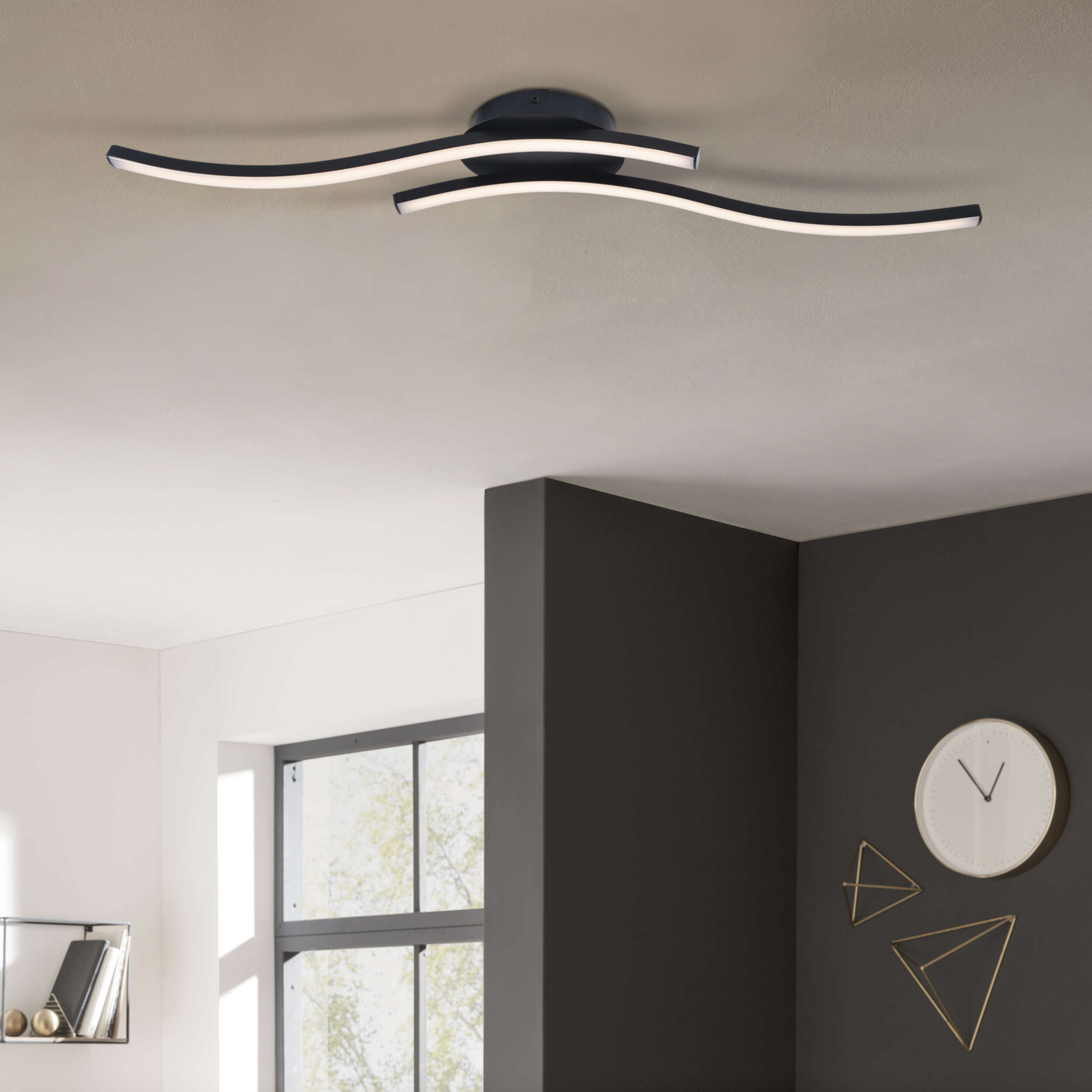 Moderne schwarze Deckenlampe mit gebogenen Lichtleisten. Dunkelgrauer und weißer Hintergrund.