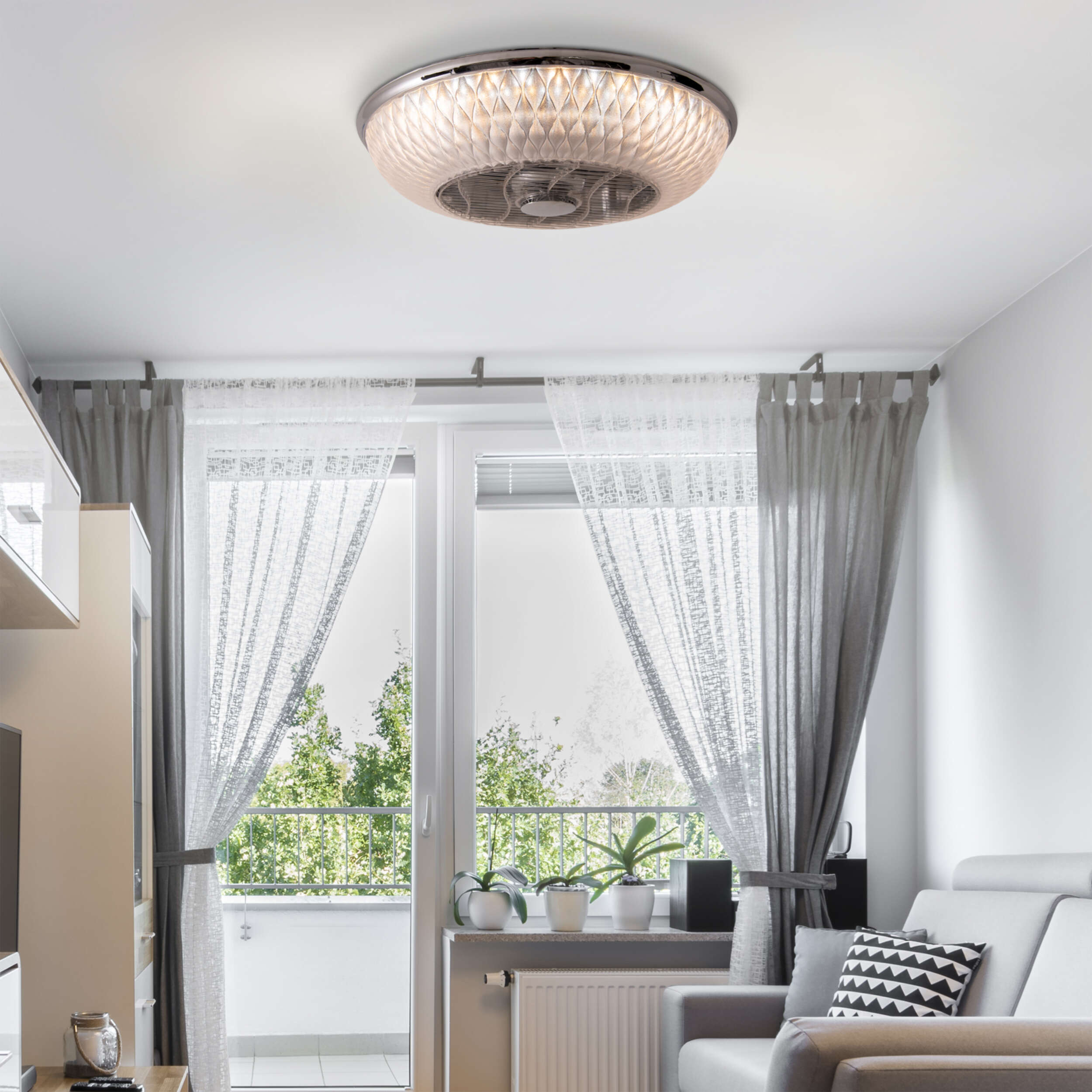 Deckenventilator mit dekorativem Licht, in einem Wohnzimmer mit Vorhängen und Sofa.