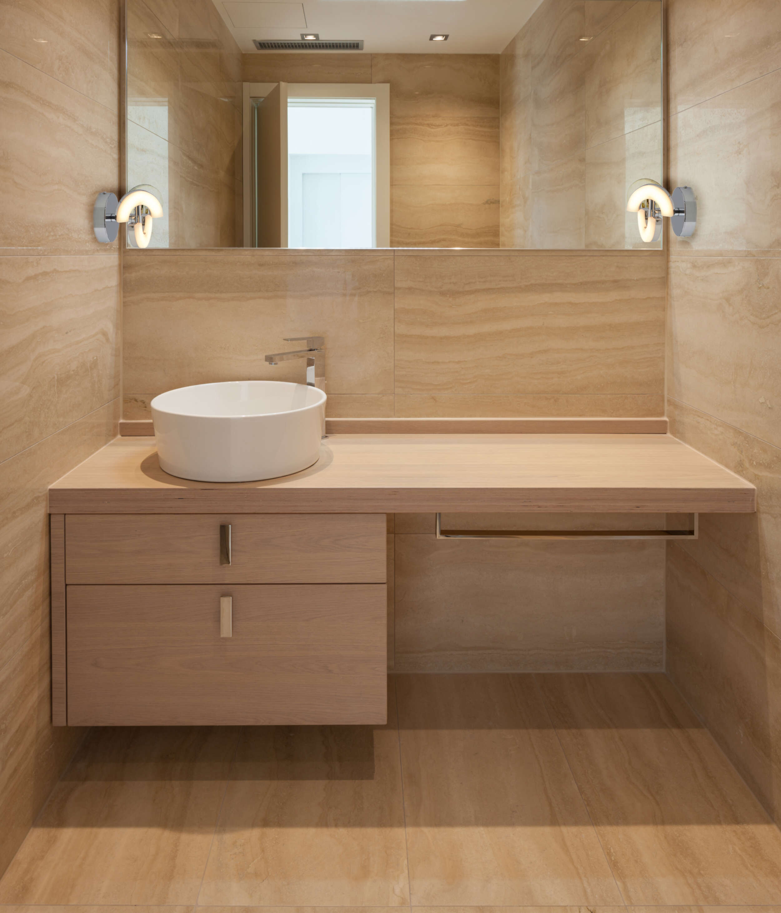 Badezimmer-Interieur mit Waschbecken, Spiegel und Lichtern. Die Wände sind gefliest.