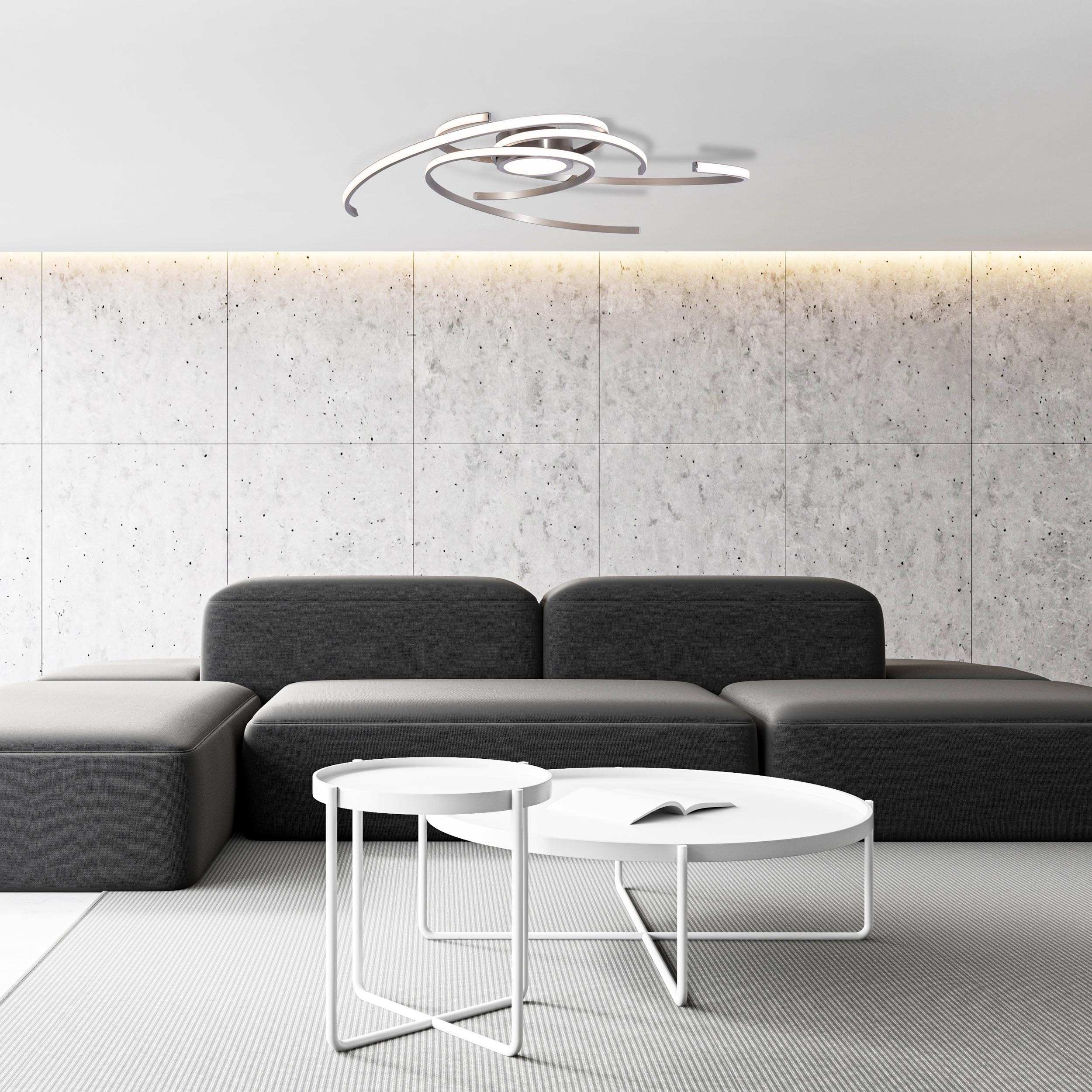 Ein modernes Wohnzimmer mit grauem Sofa, weißen Tischen und einer Deckenleuchte.