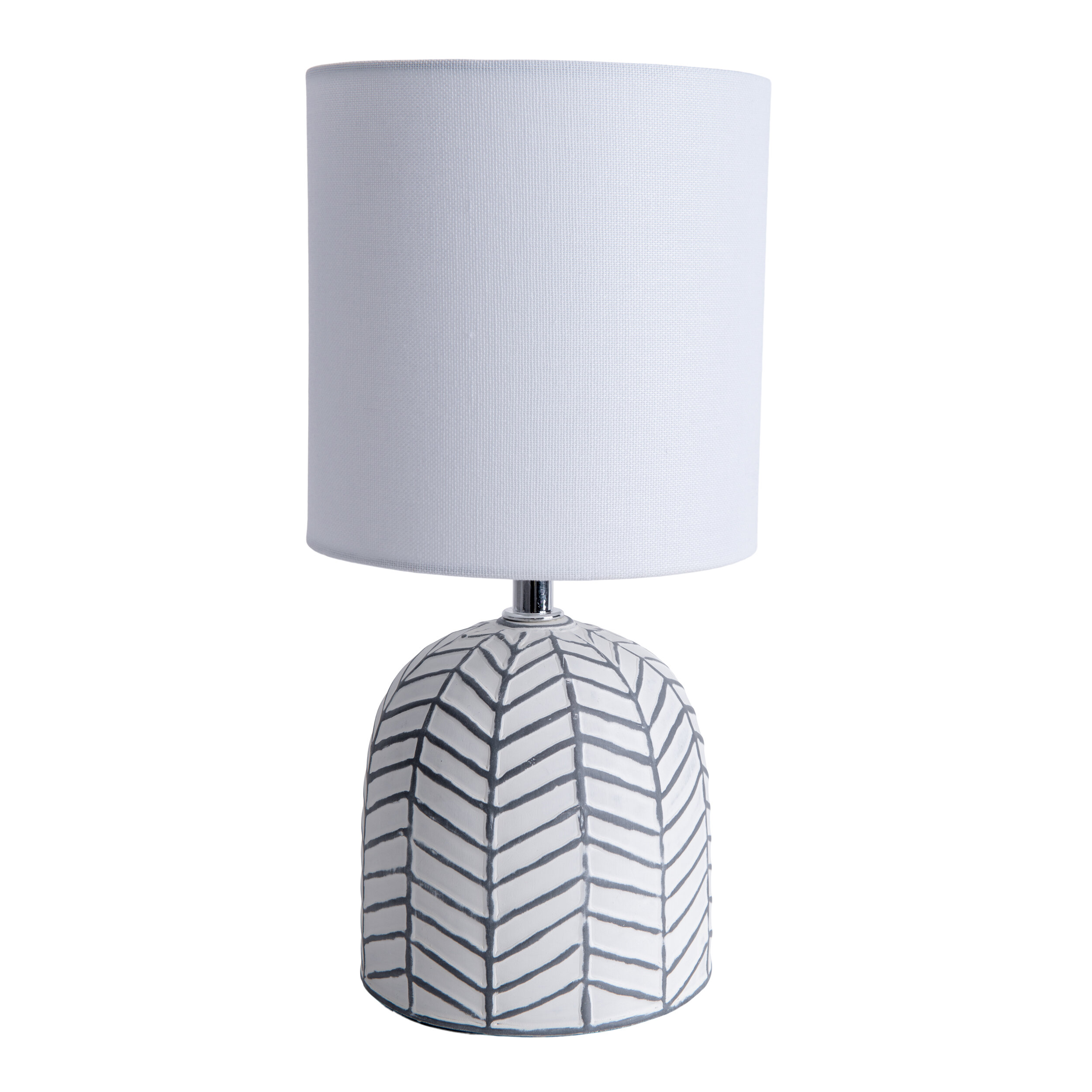 Eine weiße Tischlampe mit gemustertem Sockel und zylindrischem Lampenschirm.