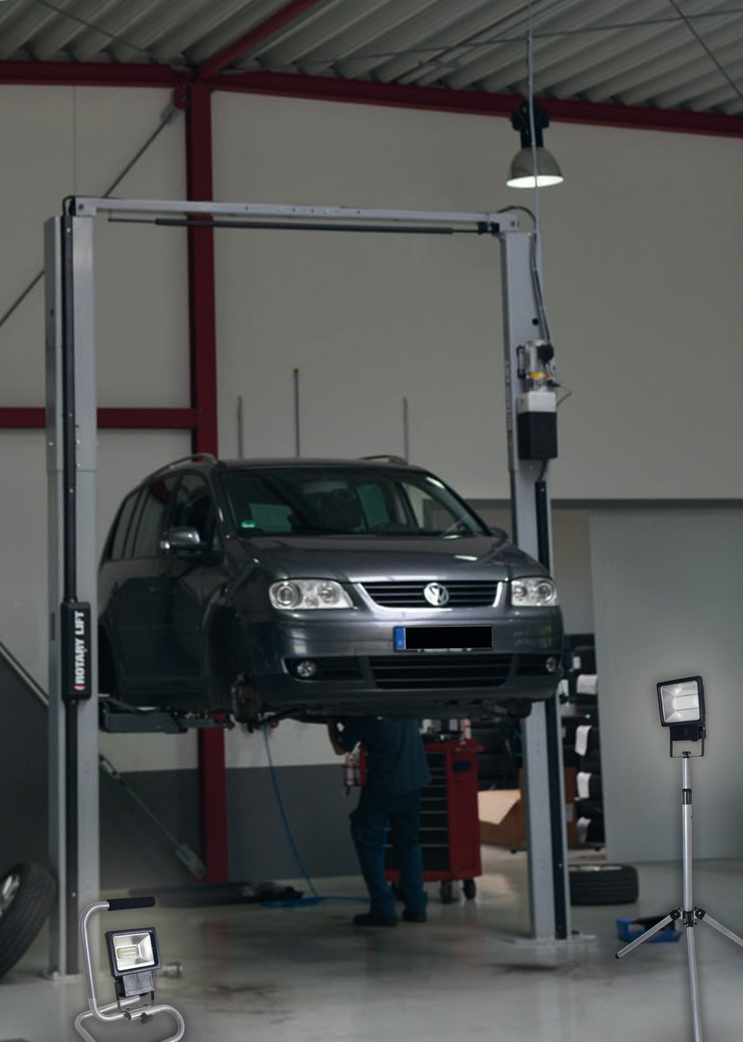 Ein Auto in einer Garage angehoben, mit Beleuchtung und einem Mechaniker darunter.