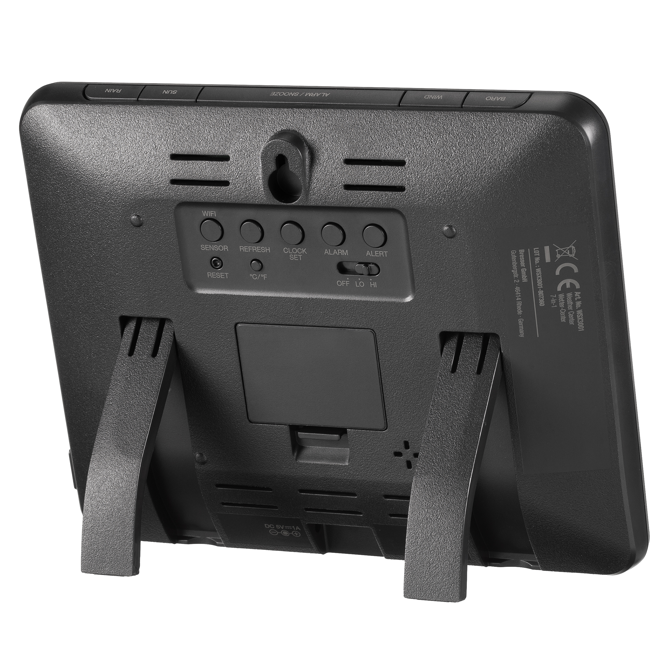 Czarny tył cyfrowego budzika z przyciskami i podstawką. Białe tło.