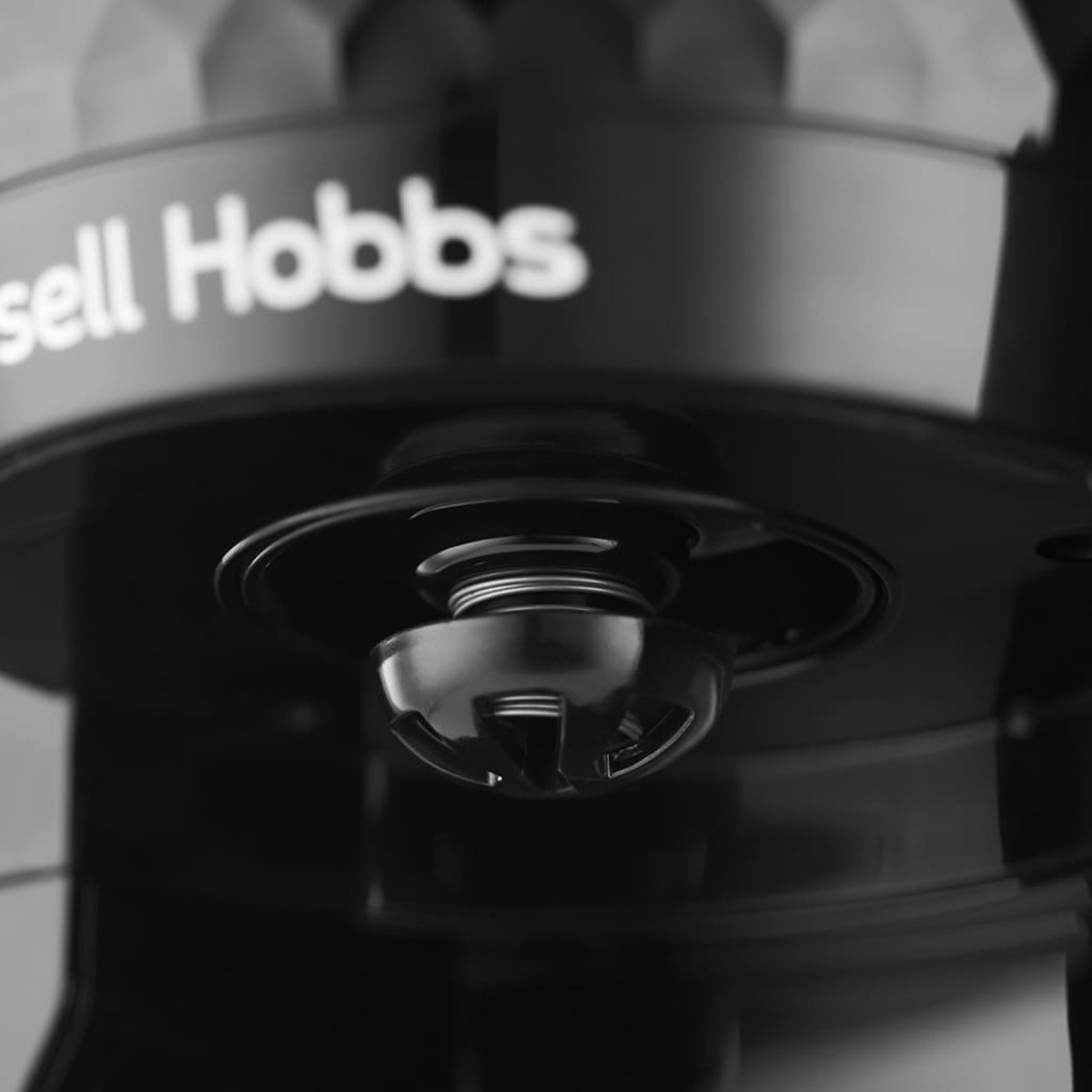 Primer plano de una cafetera Russell Hobbs, negra y plateada, con detalles.