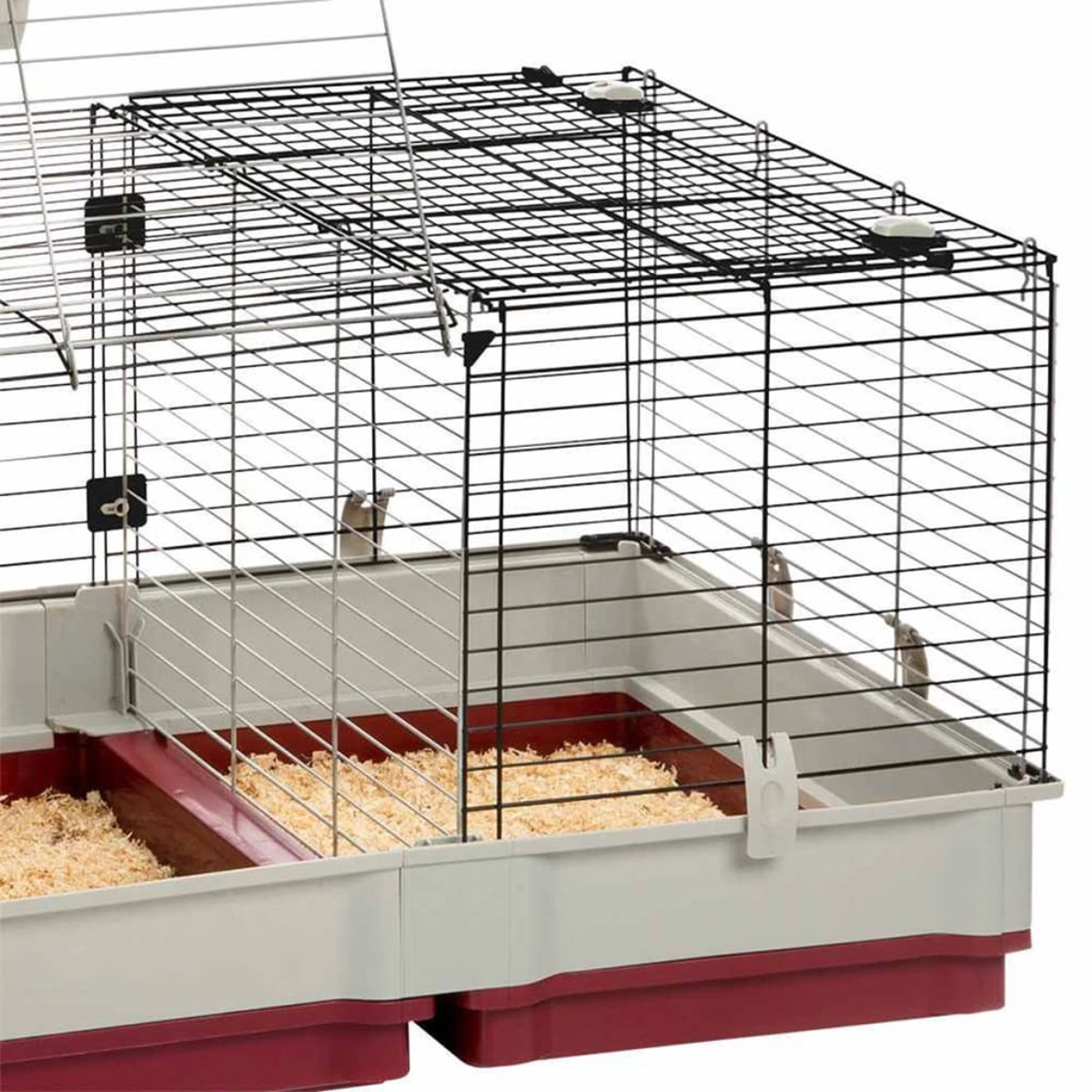 Ein Käfig für Haustiere mit Drahtoberteil, einer rot-grauen Basis und Holzspänen.