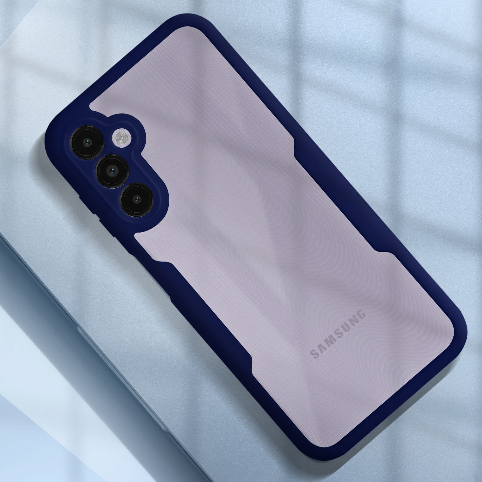 Funda de teléfono con borde azul y parte trasera transparente, sobre superficie azul claro.