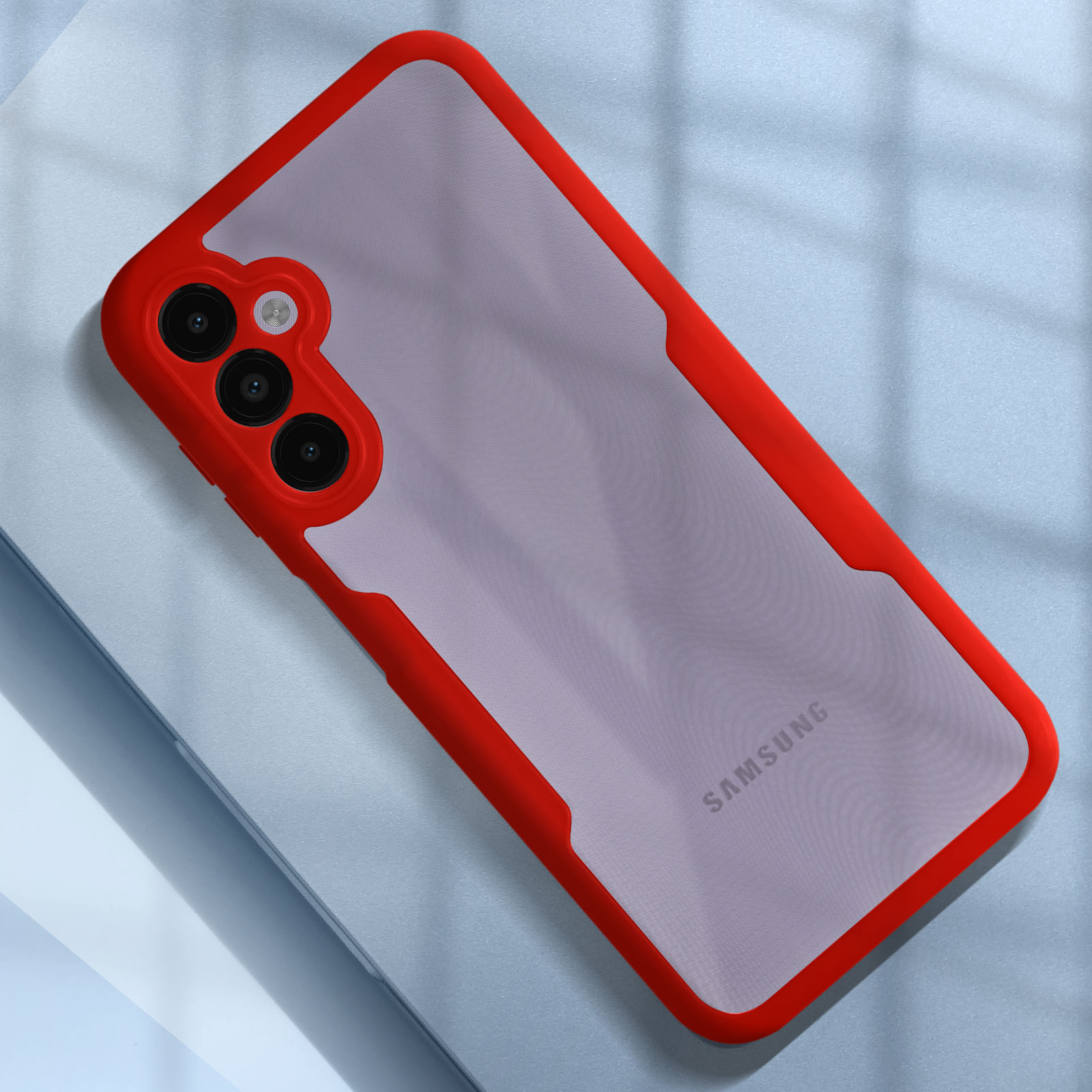 Custodia per telefono con cornice rossa e tre fotocamere su superficie blu.