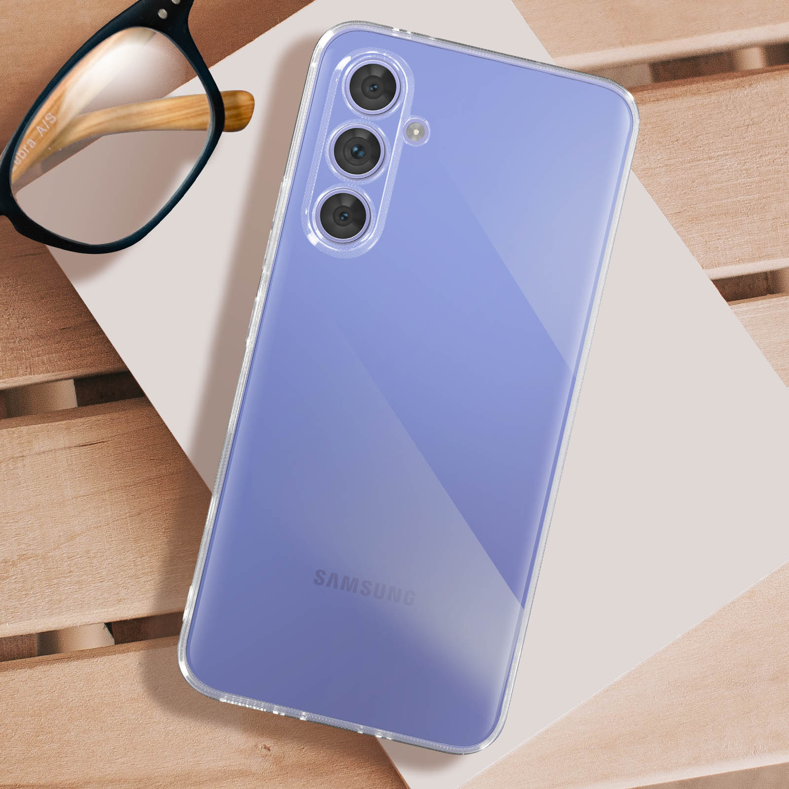 Custodia trasparente su telefono lilla, con occhiali in un angolo.