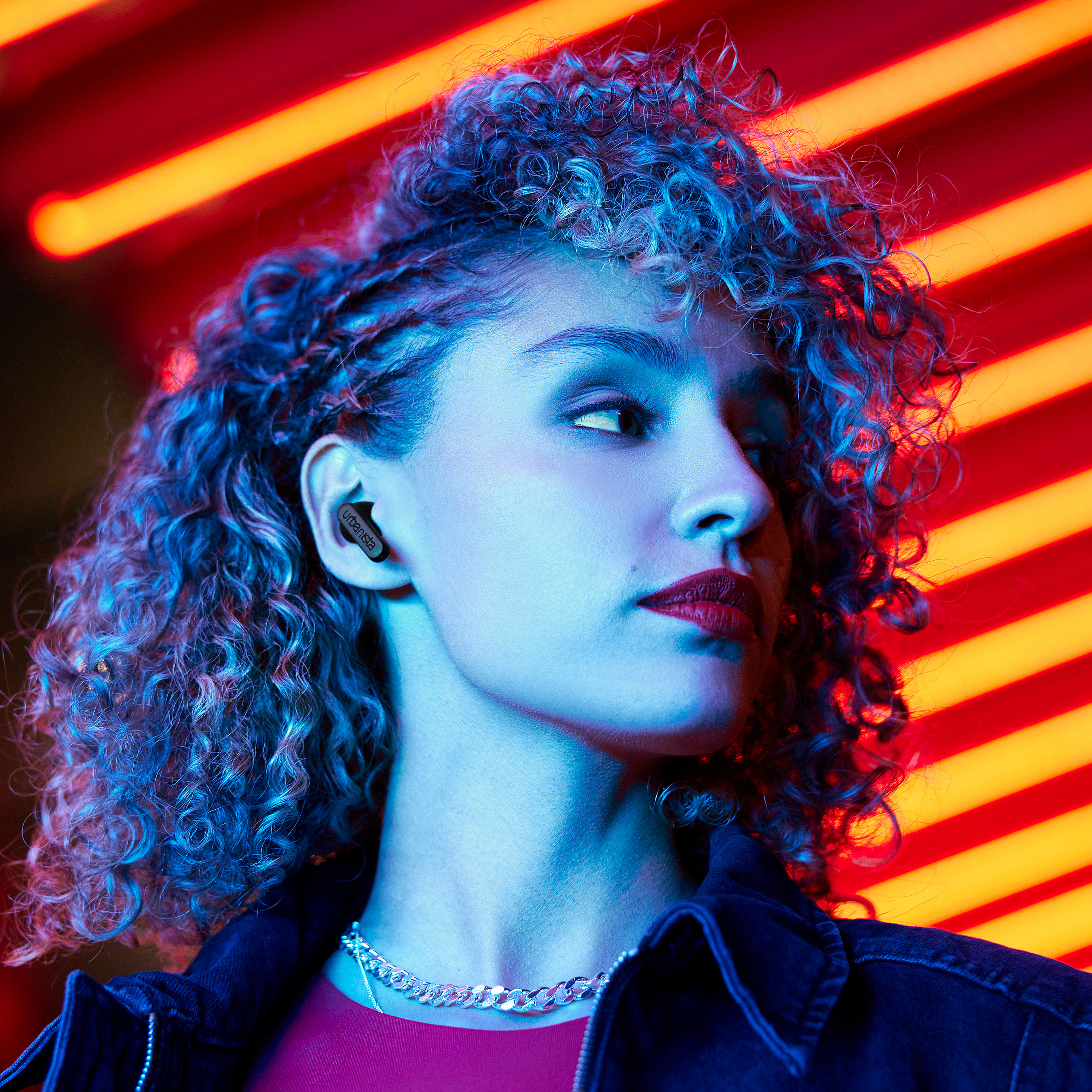 Kobieta z wkładkami dousznymi, czerwoną szminką, patrząca w bok, z neonem.