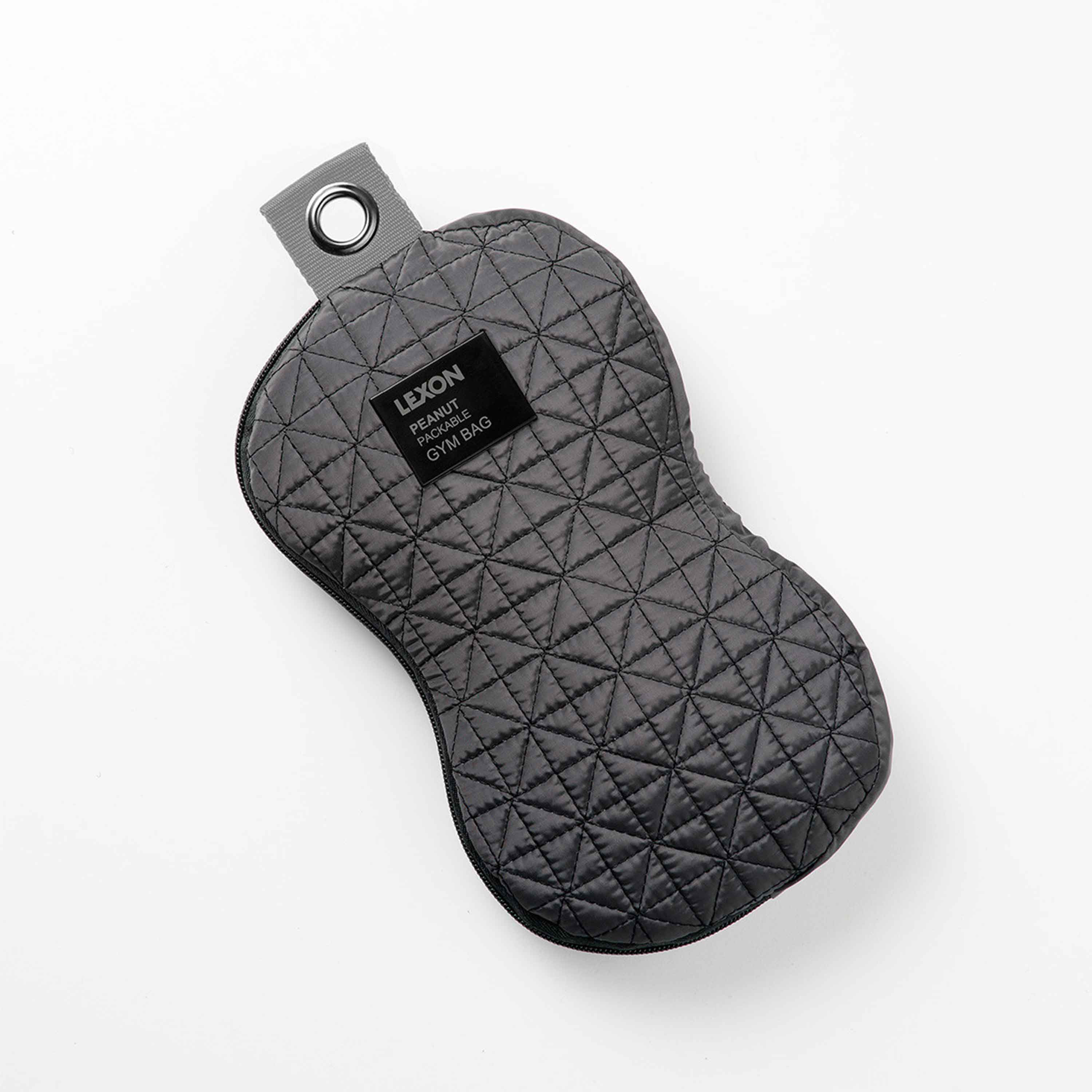 Bolsa de gimnasio gris acolchada en forma de cacahuete con etiqueta negra. Fondo blanco.