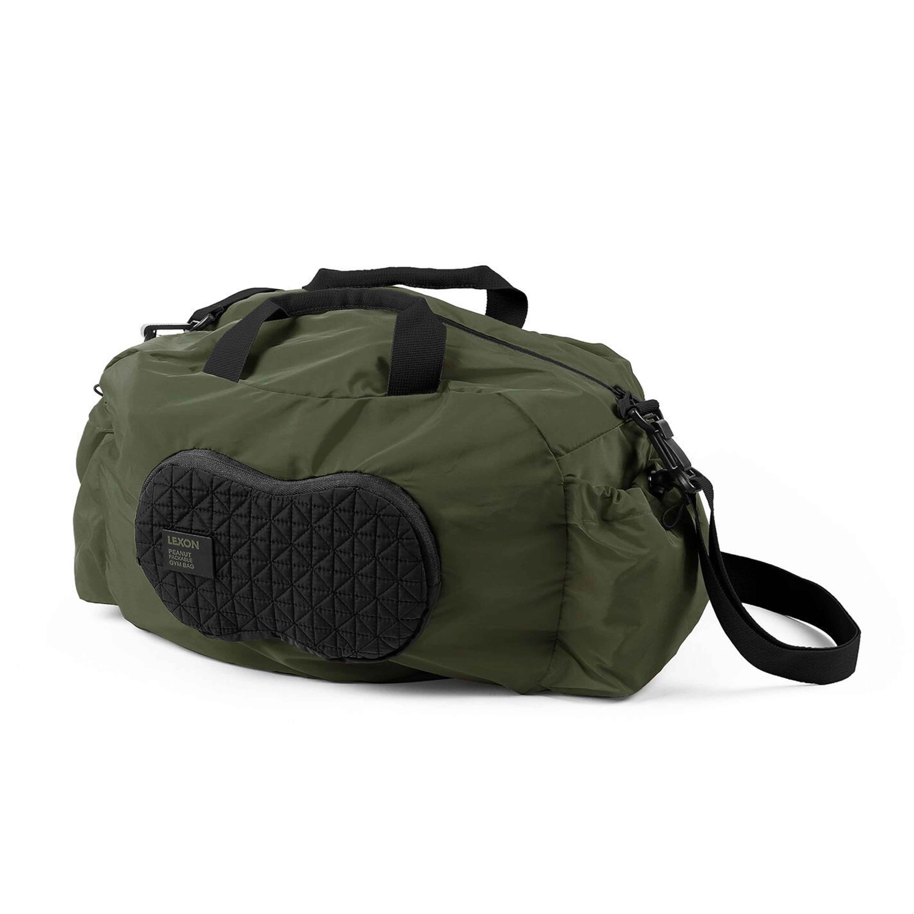 Bolsa de lona verde con asa negra y parche negro en el lateral, sobre fondo blanco.