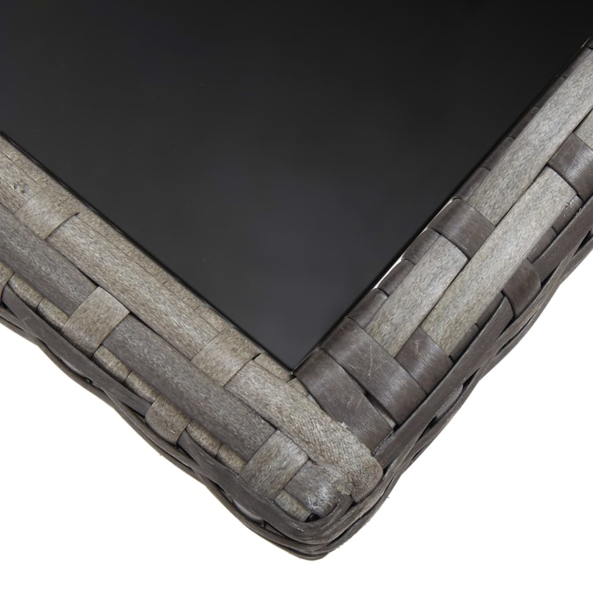 Angolo di un piano del tavolo grigio intrecciato con un inserto in vetro nero scuro su sfondo bianco.