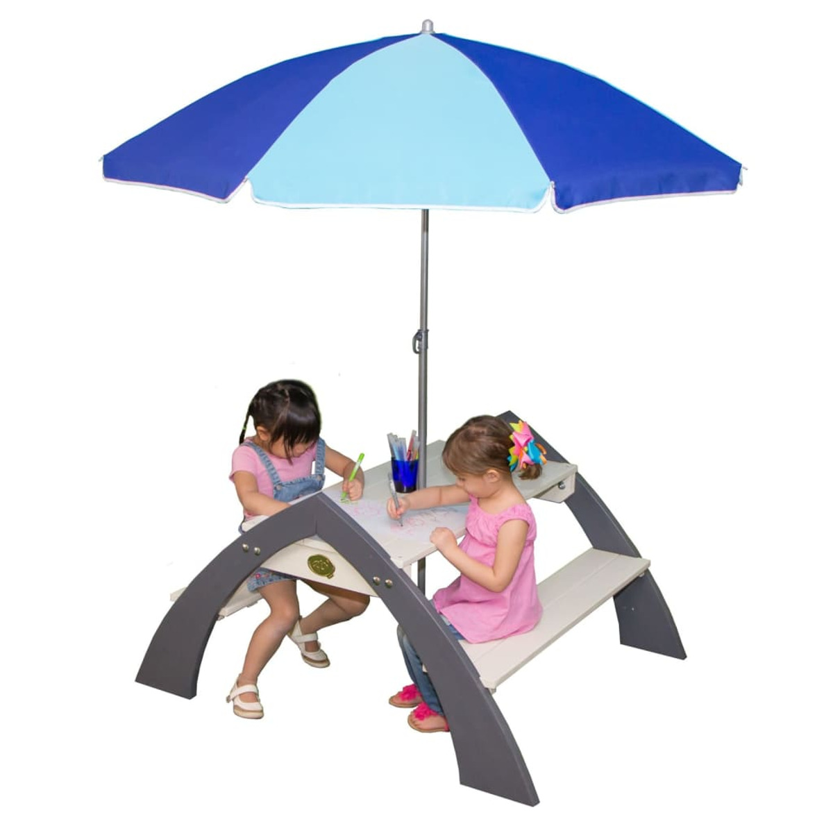 Zwei Mädchen zeichnen an einem kleinen Picknicktisch unter einem blau-weißen Schirm.