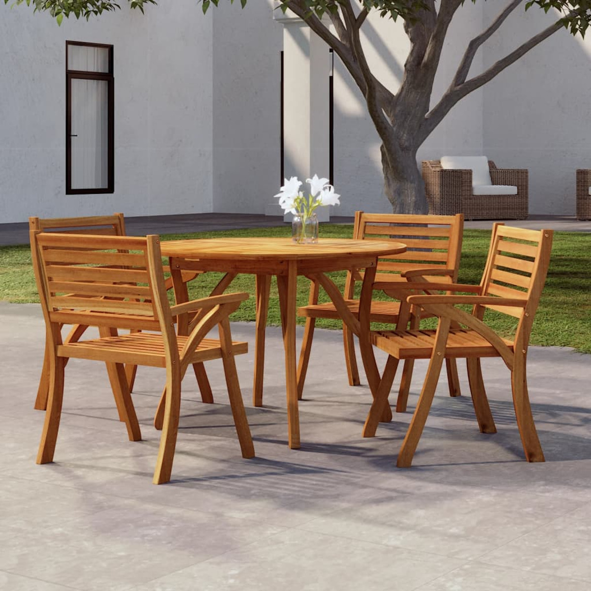 Ein Holztisch und vier Stühle stehen im Freien, umgeben von einer Terrasse und Pflanzen.