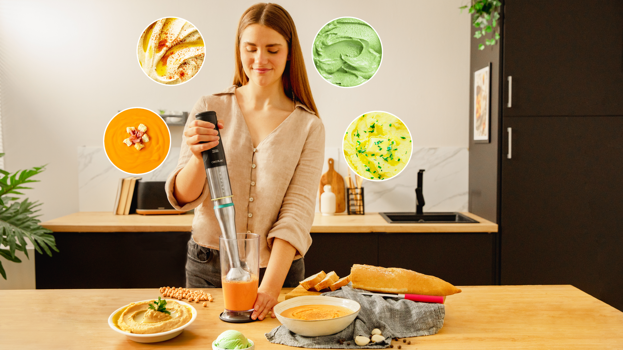 Kobieta używa blendera ręcznego do zrobienia zupy. Różne miski z jedzeniem wokół blendera.
