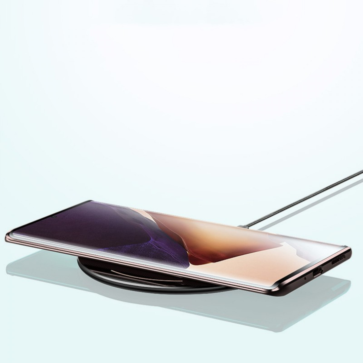 Ein Smartphone liegt auf einem kabellosen Ladegerät. Der Bildschirm des Telefons zeigt Farbverläufe. Ein Kabel ist angeschlossen.