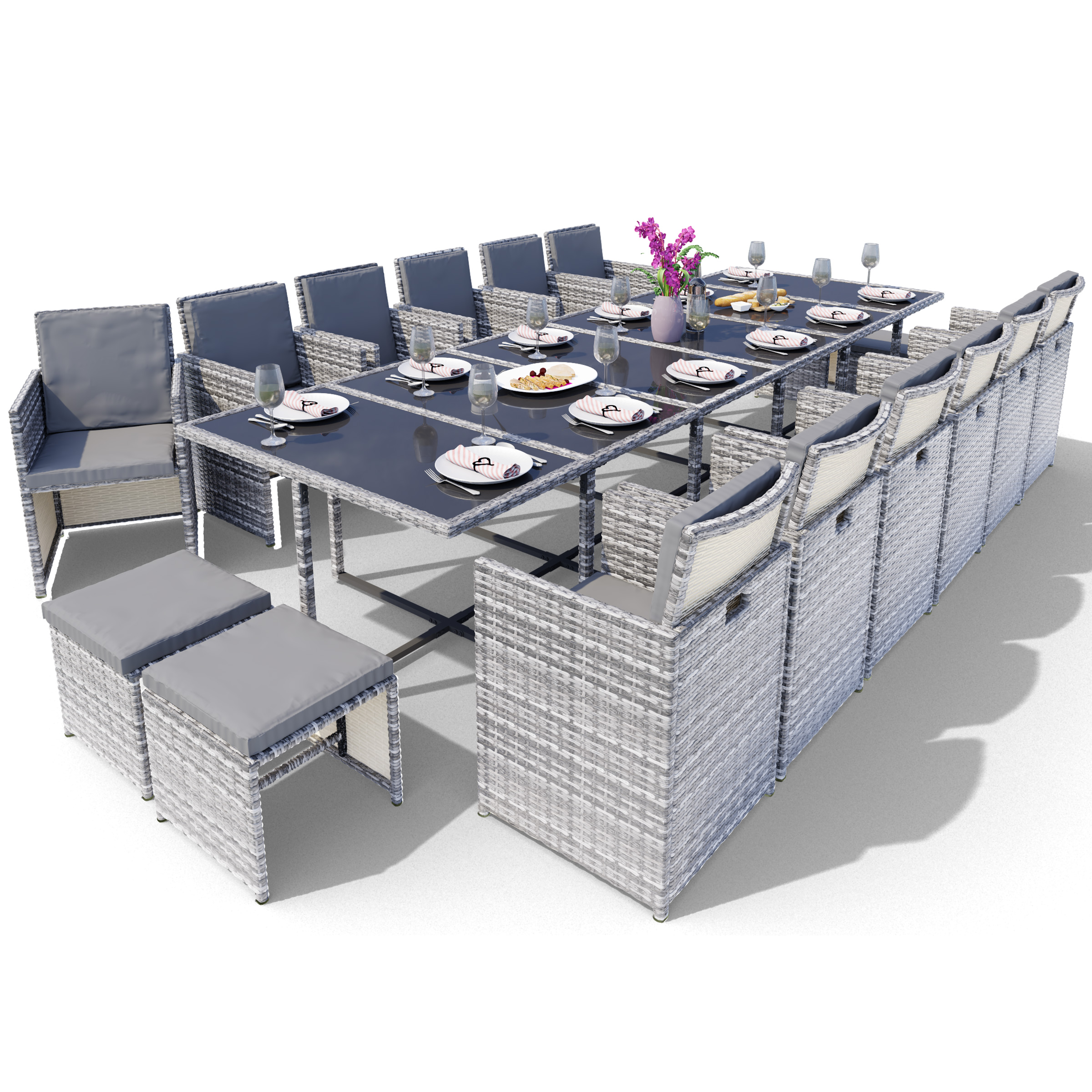 Essgruppe im Freien mit großem Tisch und Stühlen. Teller, Gläser und Blumen stehen auf dem Tisch.