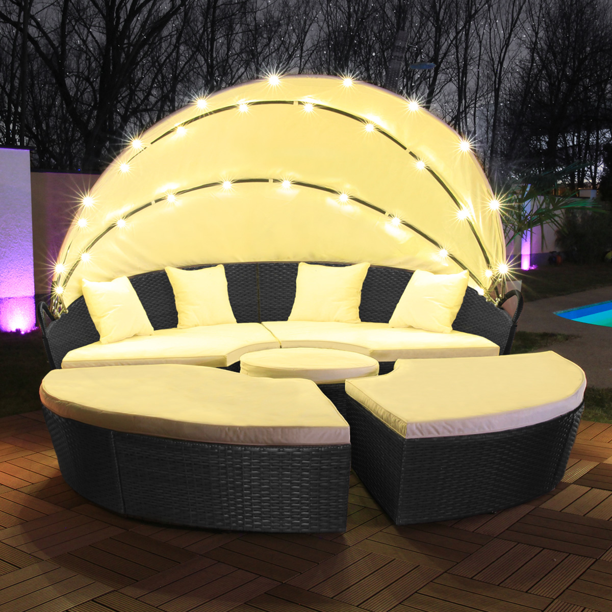 Outdoor-Sitzgruppe mit geschwungenem Sofa, Ottomanen und Tisch, mit Lichtern. Nachtszene.