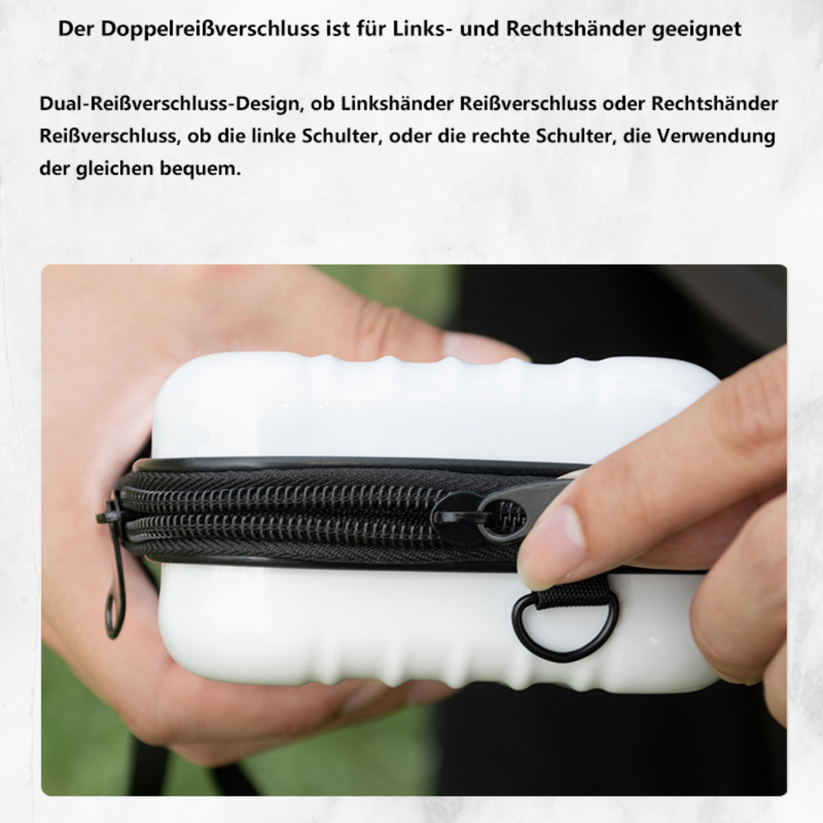Weißes Etui mit schwarzem Reißverschluss. Hand hält den Reißverschluss. Schwarzer D-Ring an der Seite.