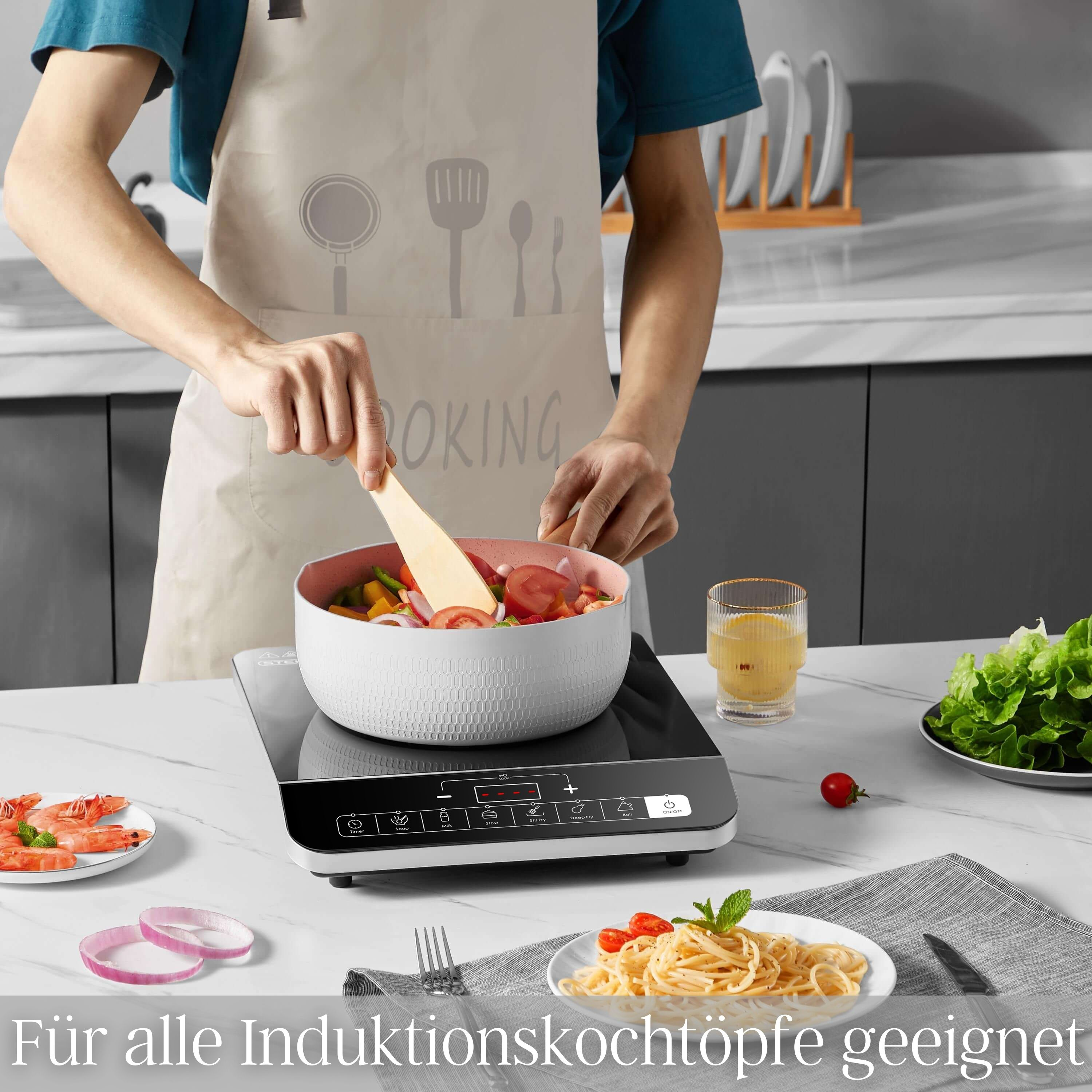 Person kocht in Küche. Induktionskochfeld mit Essen. Verschiedene Gerichte auf dem Tisch.