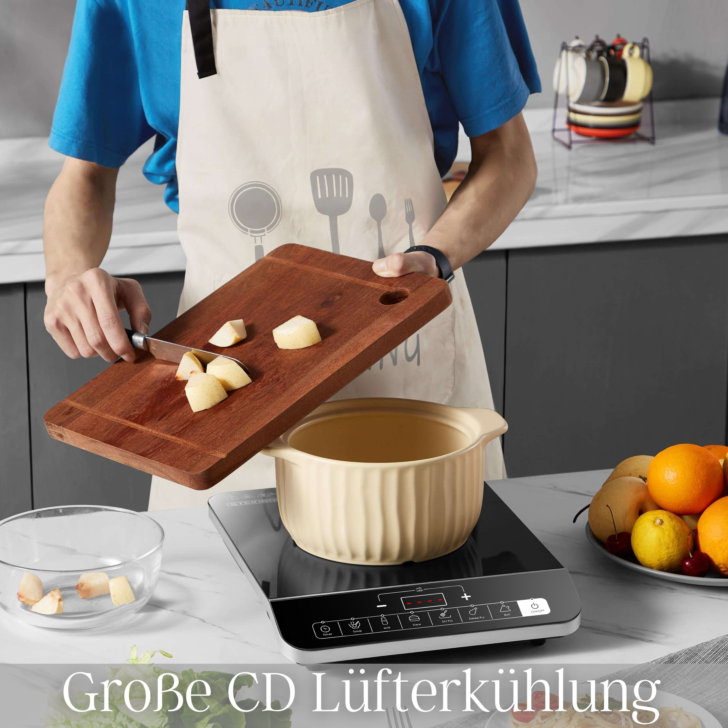Eine Person schneidet Kartoffeln auf einem Holzbrett; ein Topf und ein Induktionskochfeld sind sichtbar.