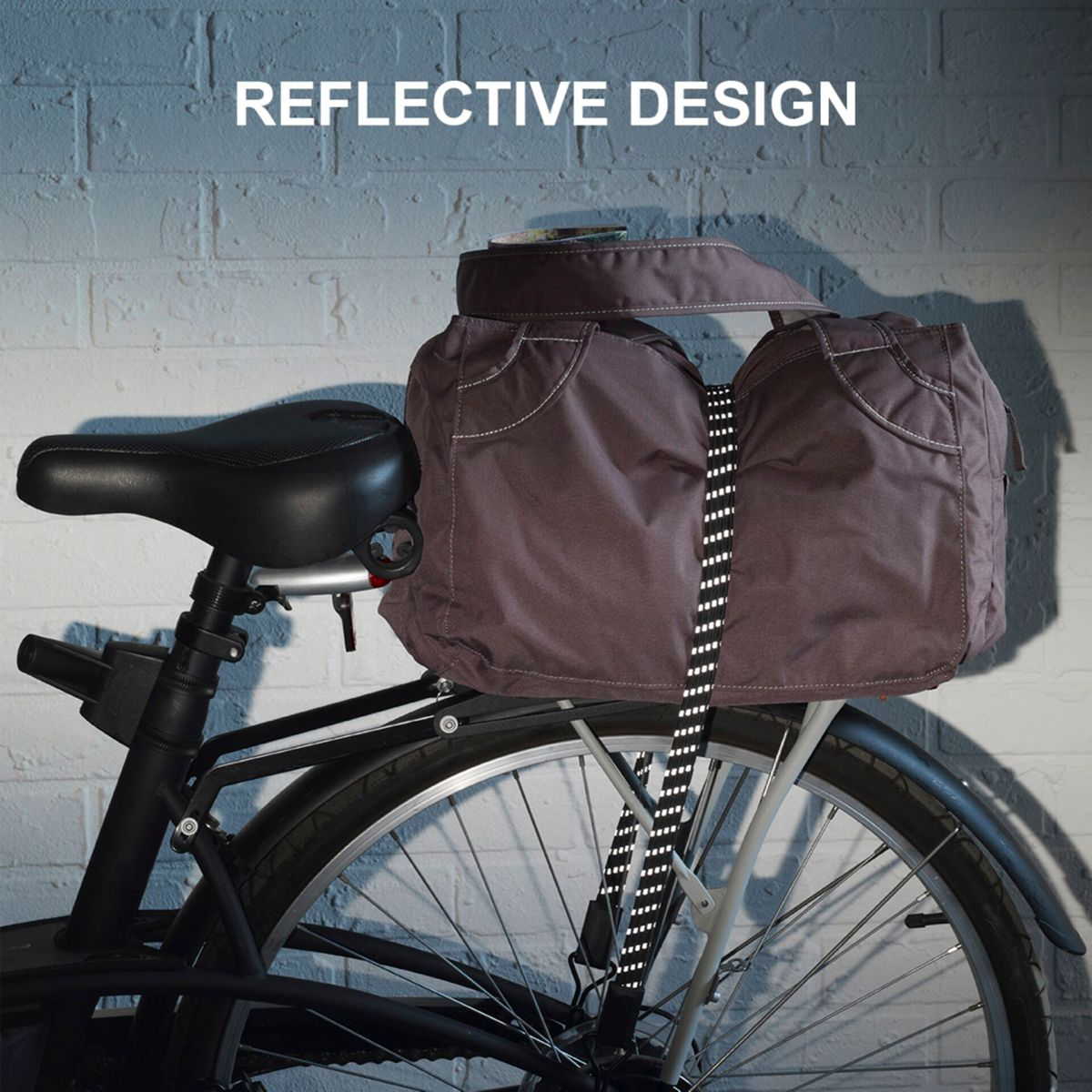Una bici con borsa posteriore e design riflettente, con la bici su un muro di mattoni.