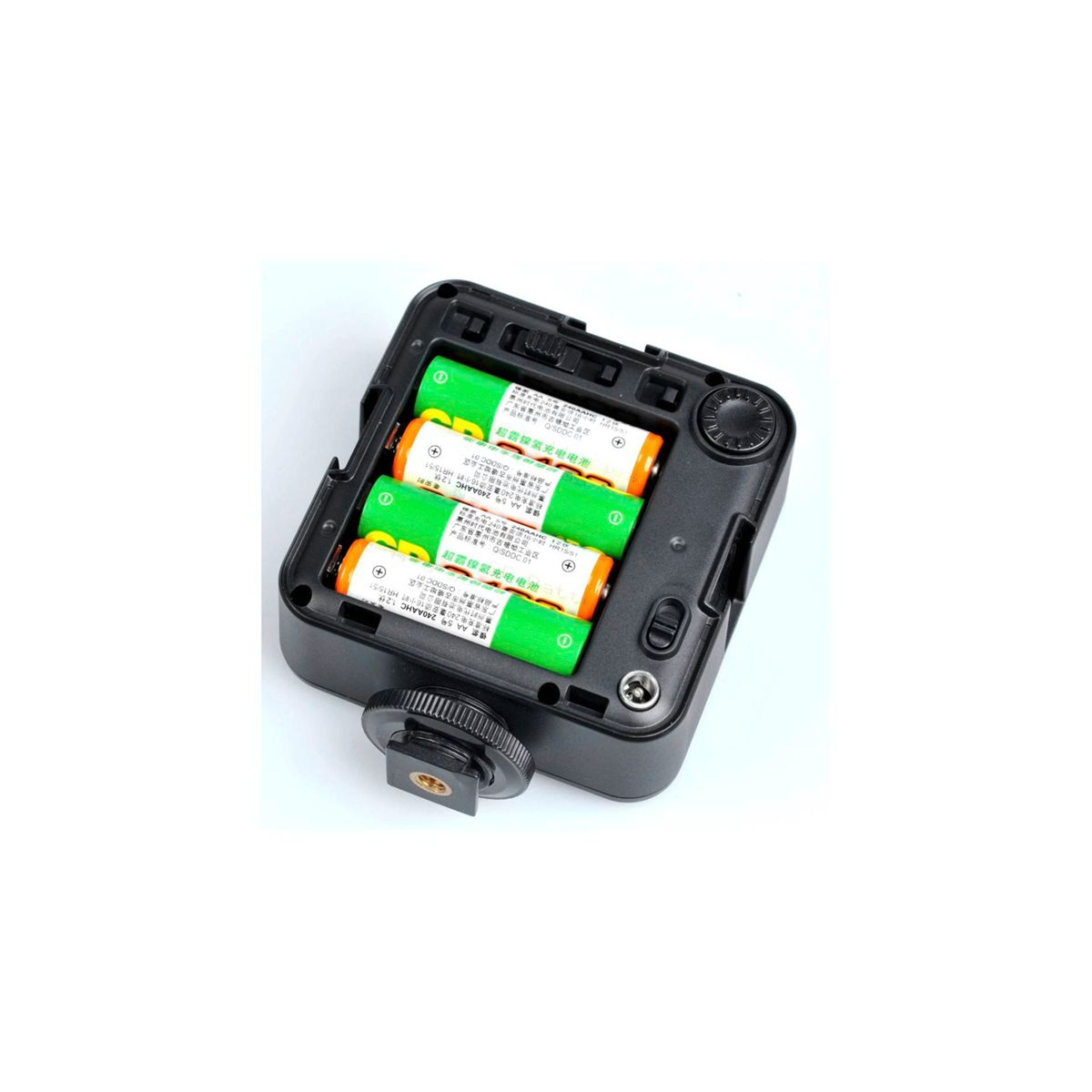 Otwarta komora baterii z czterema zielono-białymi bateriami AA w środku. Czarna obudowa.